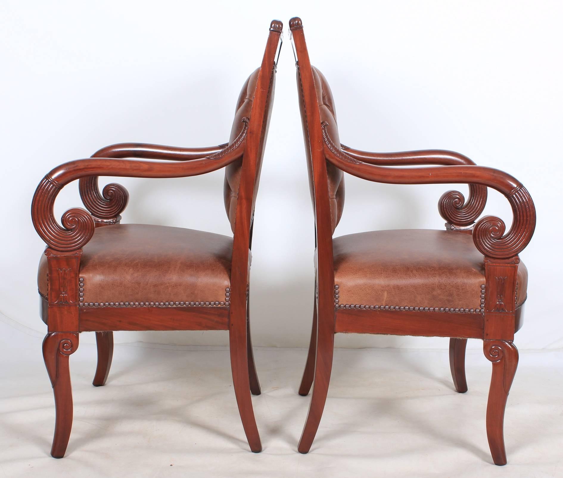 French, circa 1850.
A fantastic pair of Empire style library chairs in showroom condition.
Newly upholstered in a top quality chocolate brown leather with studded edging.
Beautiful scroll arms with reeded hand rests.
On sabre legs with