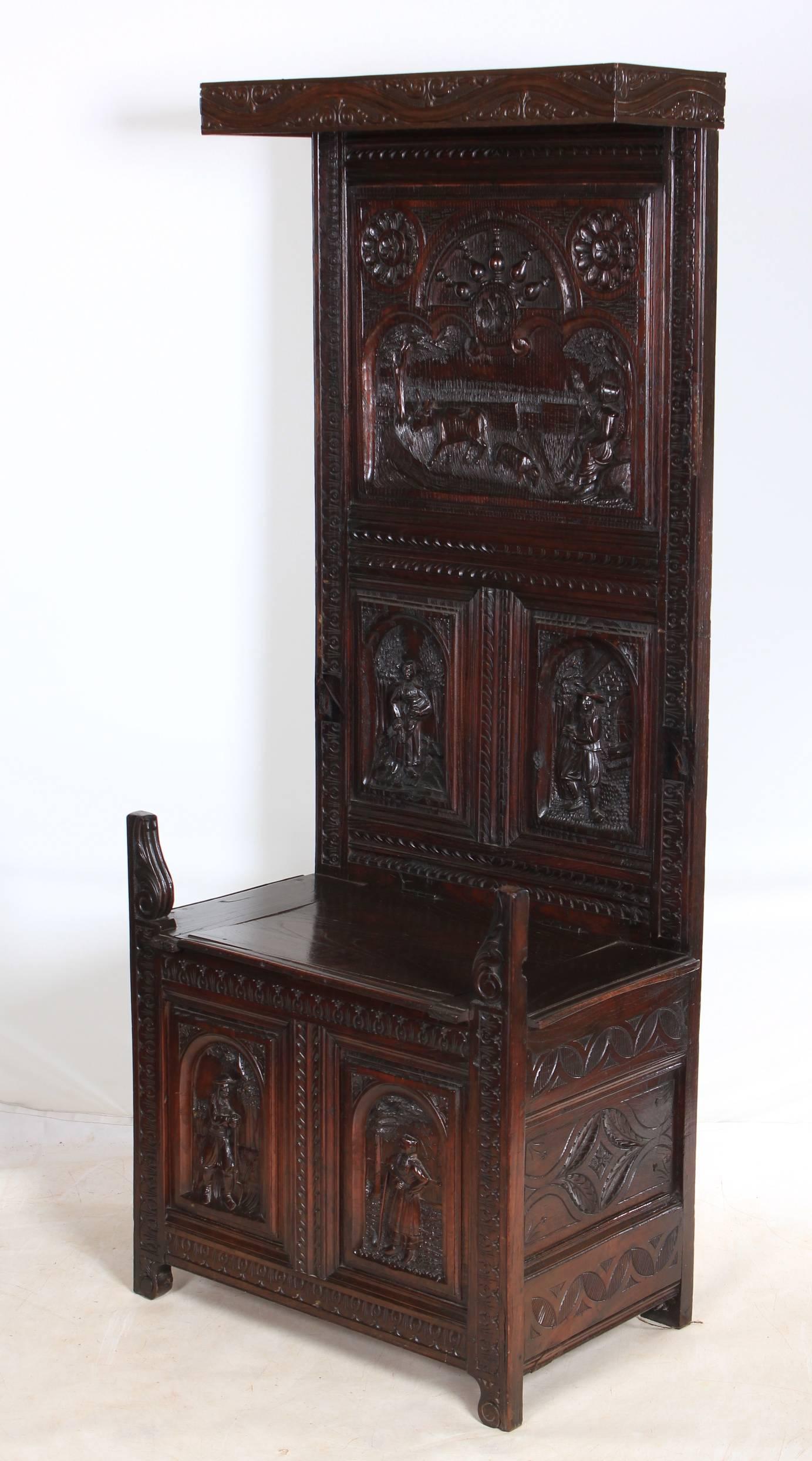 English, circa 1880.
This fantastic carved oak porters chair is in great condition. It is profusely carved all over, the back panel shows farmyard scenes and sits behind a box seat base.
The lid of the seat opens to reveal a storage