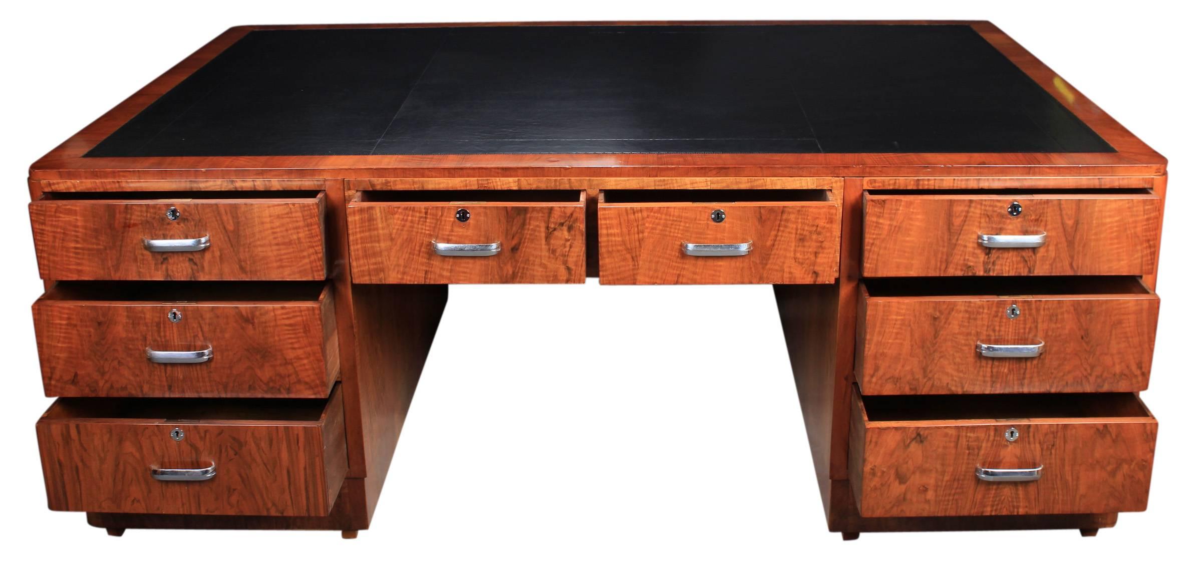 English, circa 1930.
This enormous desk is an absolute stunner offered in showroom condition.
It has a newly fitted black leather writing surface.
There are eight large drawers either side of the desk with gorgeous figured walnut fronts and