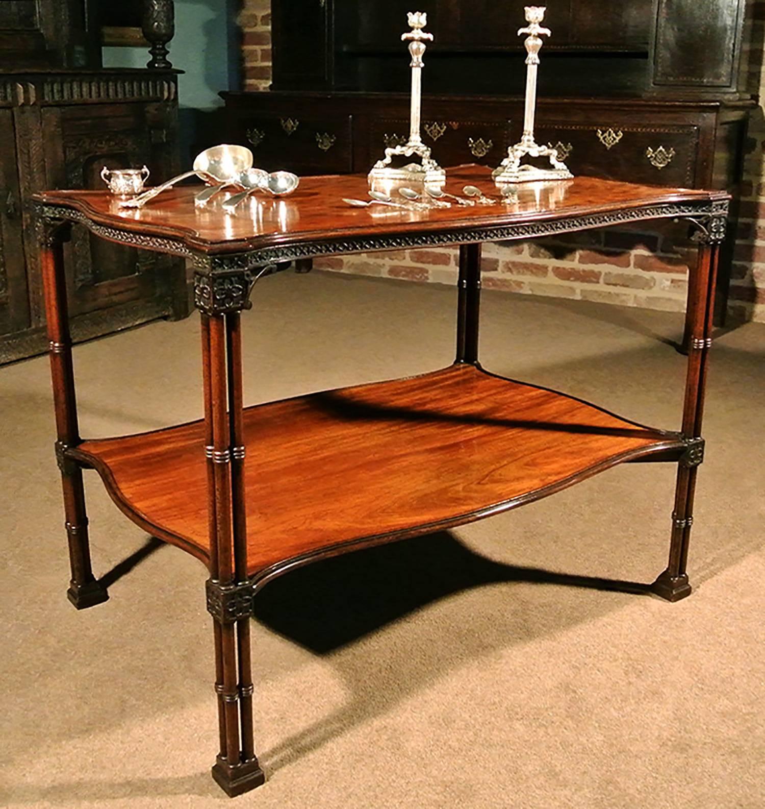 With a superb color, an extremely rare and fine example of a solid mahogany silver table, circa 1760 in the manner of Thomas Chippendale.

The two solid mahogany serpentine shaped tiers set on finely ring turned cluster column legs. The upper tier
