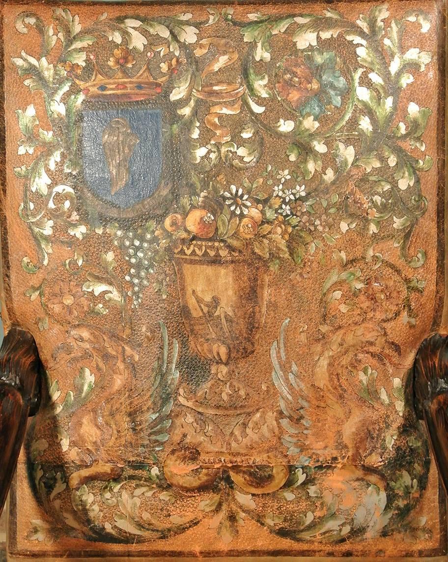 With original hand-painted leather upholstery, a marvellous and well carved pair of 18th century solid walnut throne chairs with substantial leaf wrapped and scrolled arms and large naturalistic hairly lion paw feet, with acanthus leaves carved to