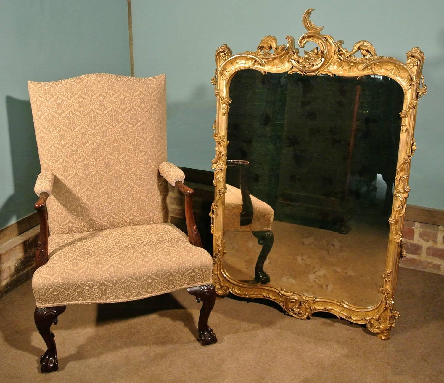 A very fine and elaborately carved George II giltwood frame with a later mirror plate (the plate made with some distressing to appear much older). 

This was originally a floor standing screen and the decoration is identical to both sides. It