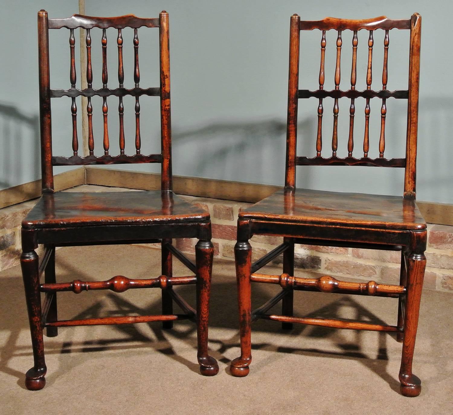 A very good pair of mid-18th century elm spindle back chairs. Of charming form and with a fantastic color and deep natural patination, the chairs are solid and robust and extremely eye-catching.

Original and complete spindles and stretchers, all