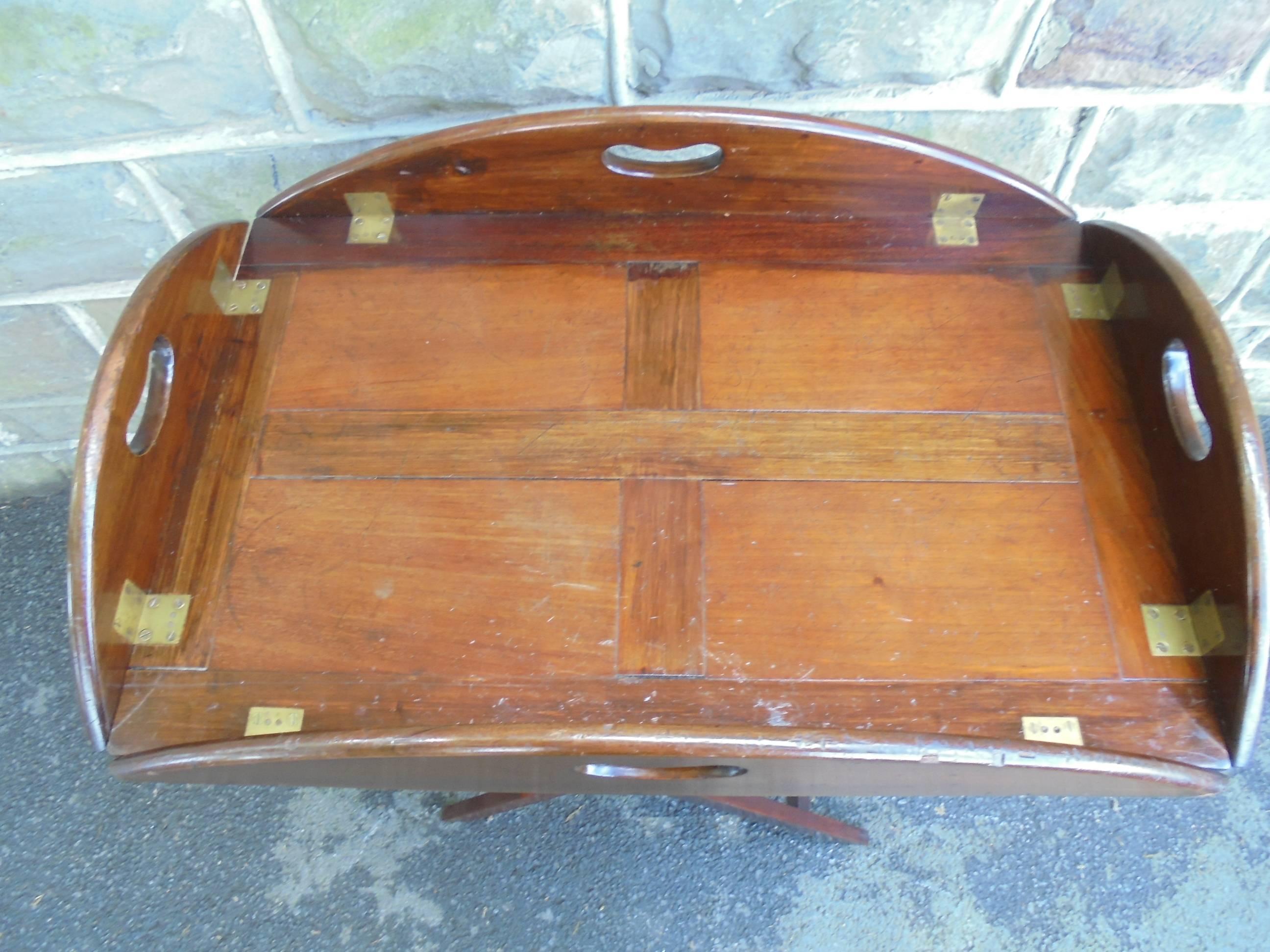 Offered for sale is this quality mahogany butlers tray on stand.

The mahogany folding frame stand having stamped registration numbers. The removable mahogany tray has fold down sides with cut-out handles and brass hinges.

Offered in very good