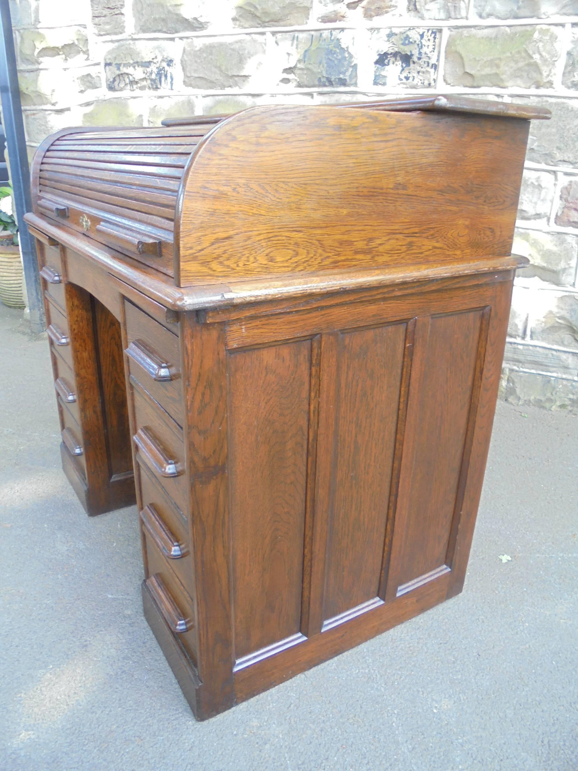 Offered for sale is this Edwardian oak roll top desk. 

Dating from 1900. Made from solid oak. It has a tambour roller top. Inside it has a series of pigeon holes and four draws. It has two pull-out slides perfect for using a mouse on or putting