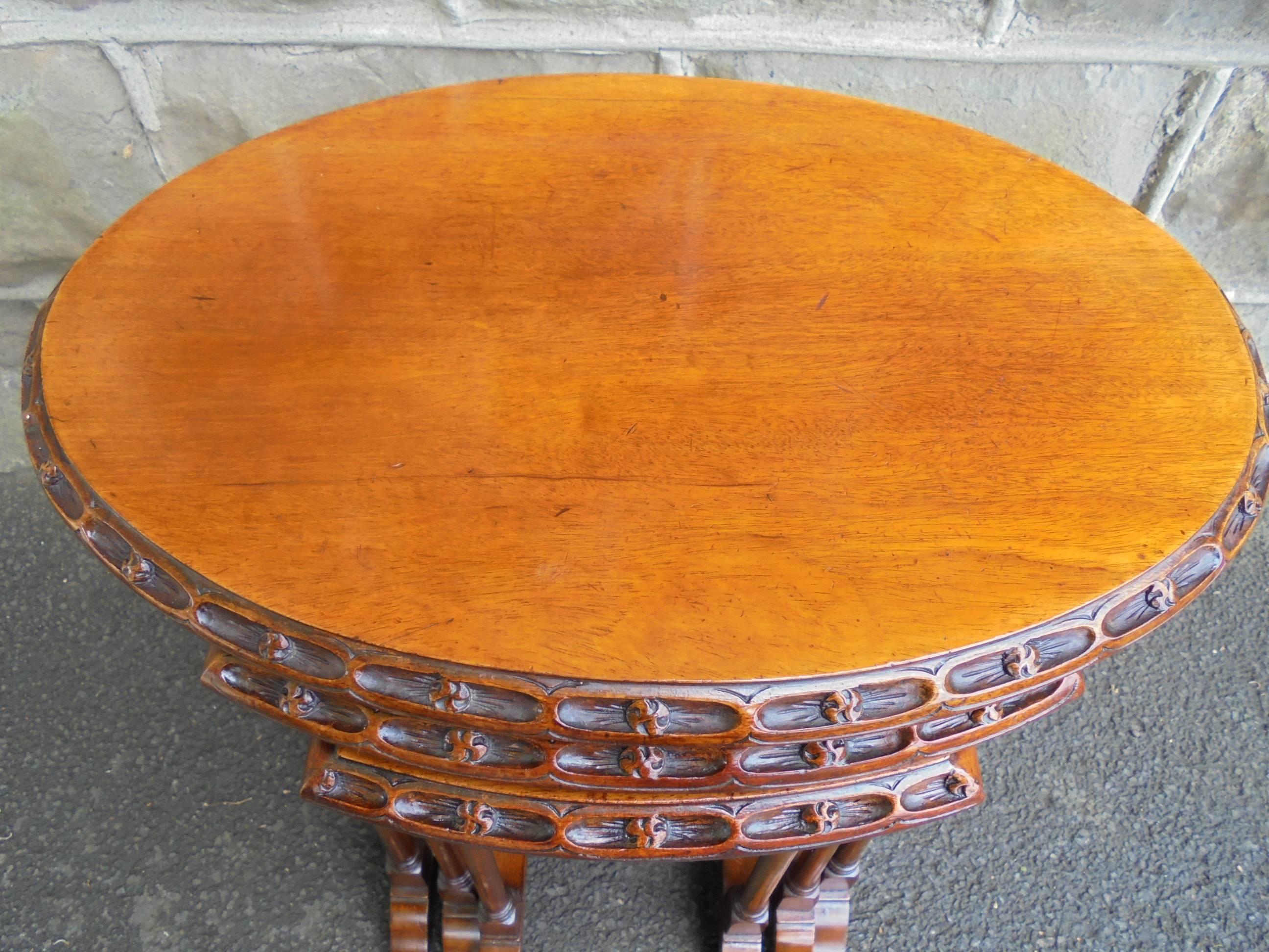 Offered for sale is this antique nest three mahogany tables

Oval solid mahogany top with carved decoration to the front & back edges of each table. Standing on twin turned pedestal supports with shaped feet. The smaller tables slide under each
