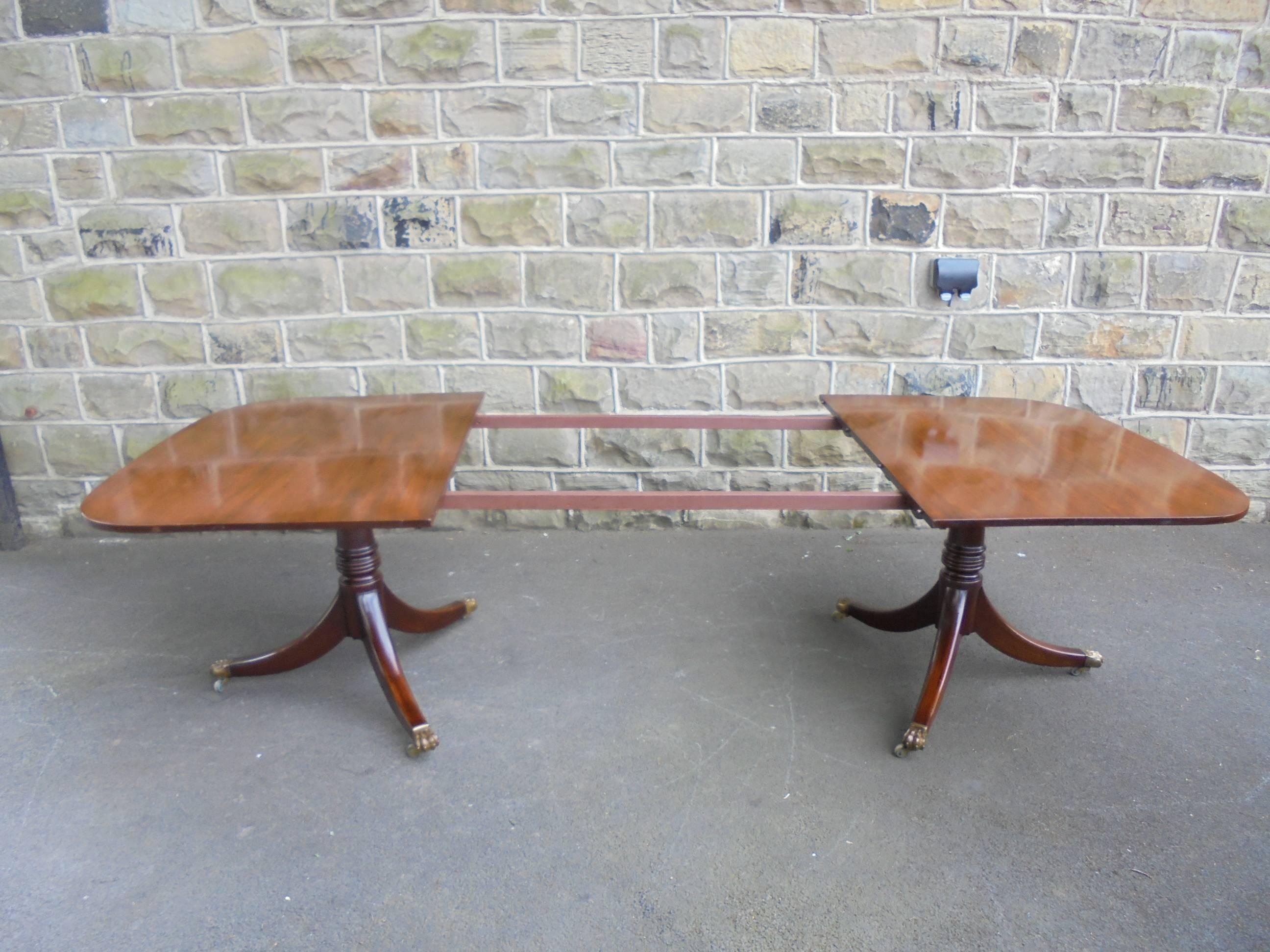 Offered for sale is this wonderful quality twin pillar extending dining table. Would seat 10-12 people comfortably.

In the Regency style dating from 1910. Made from solid mahogany. Two ends standing on turned columns, three splayed legs with