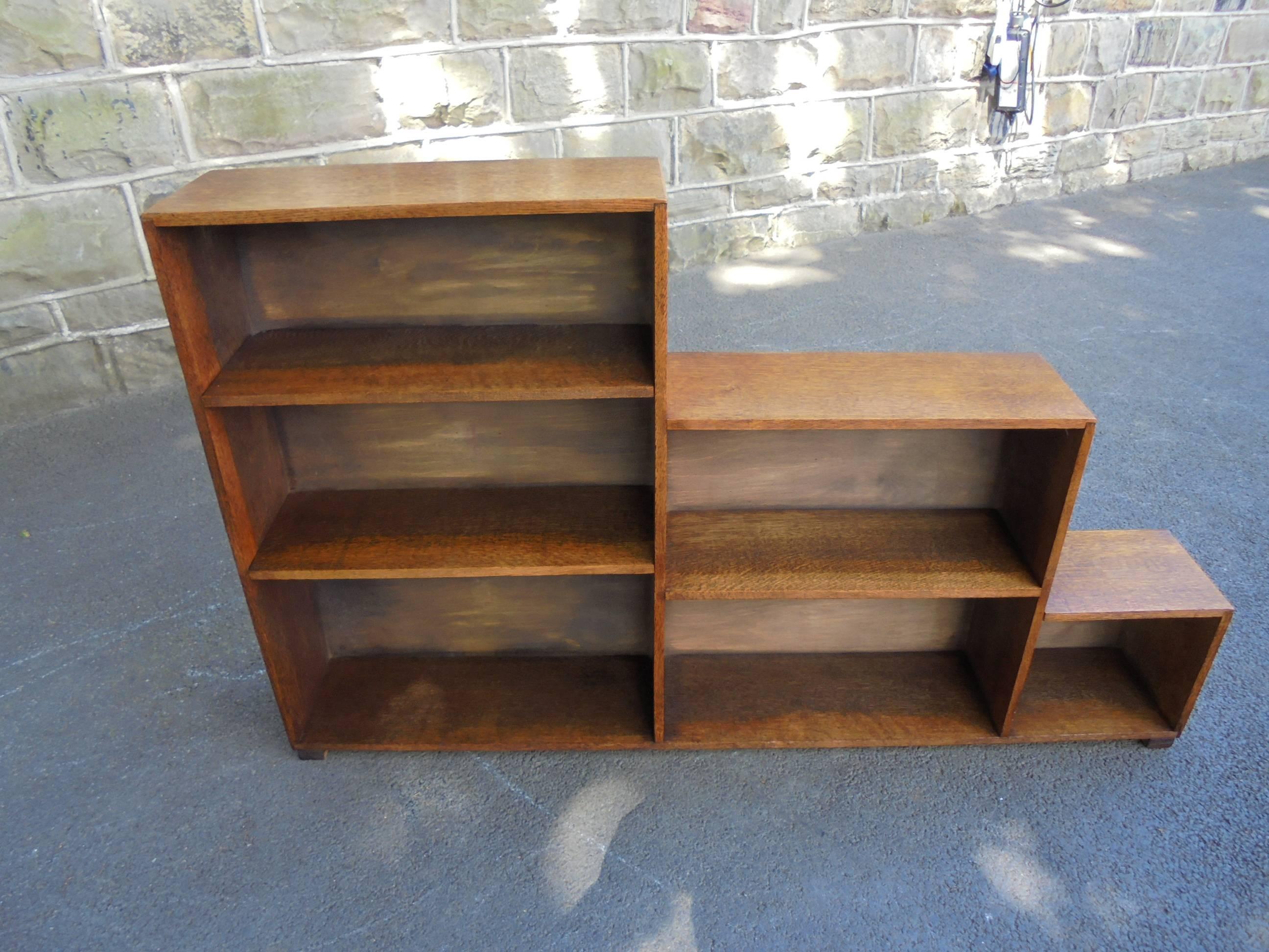 Offered for sale is this antique stepped oak bookcase.

In the manner of Heals. Solid oak which is a light colour, stepped bookcase with open fixed height shelving for bookcase. Standing on square block feet.

Offered in good clean original