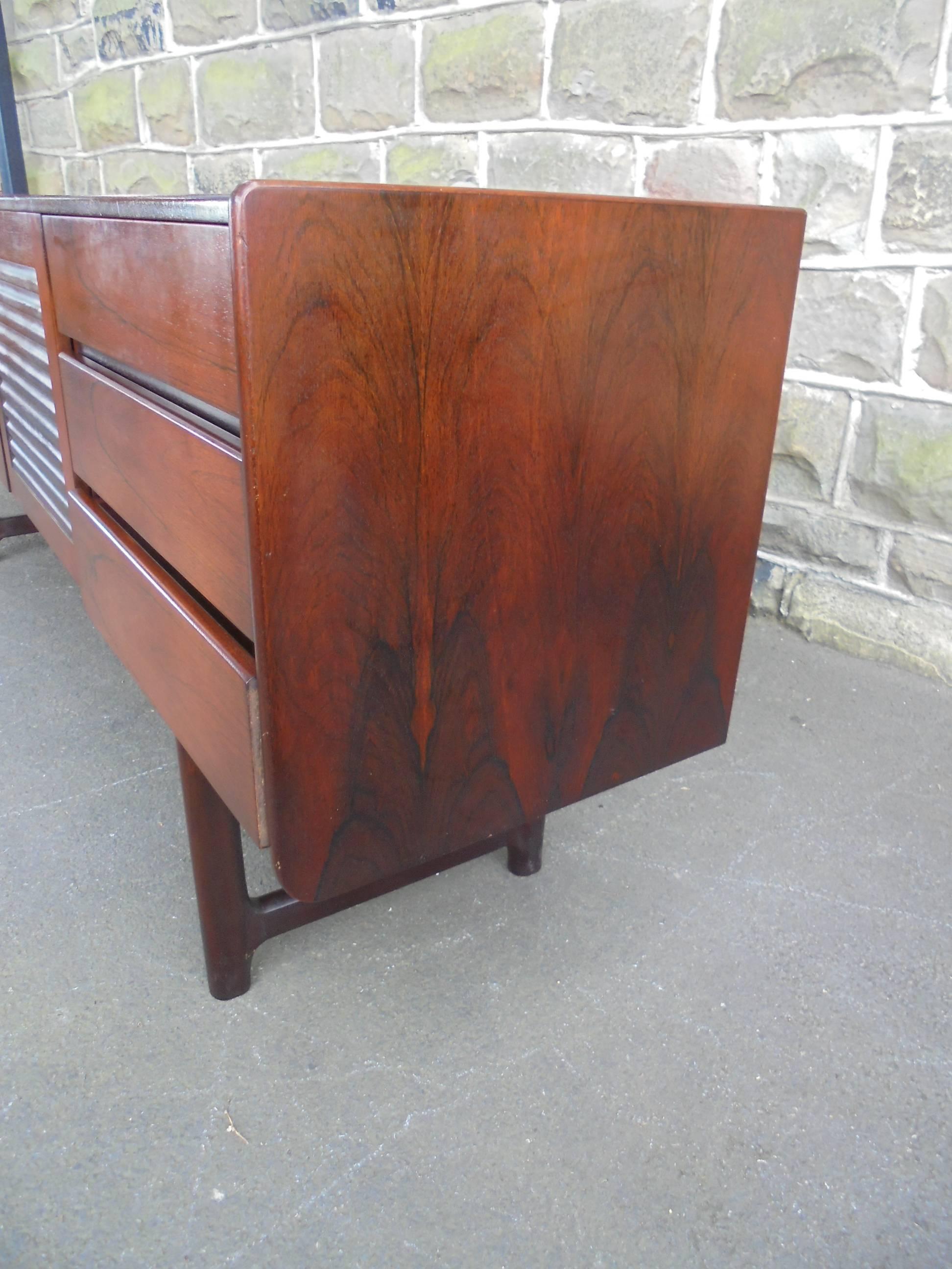 Offered for sale is this good retro 1960s rosewood sideboard by McIntosh.

Nice long sideboard in rosewood with three-draws and cupboard doors with louvre fronts & brass handles. Standing on rounded rosewood legs.

Offered in good clean original