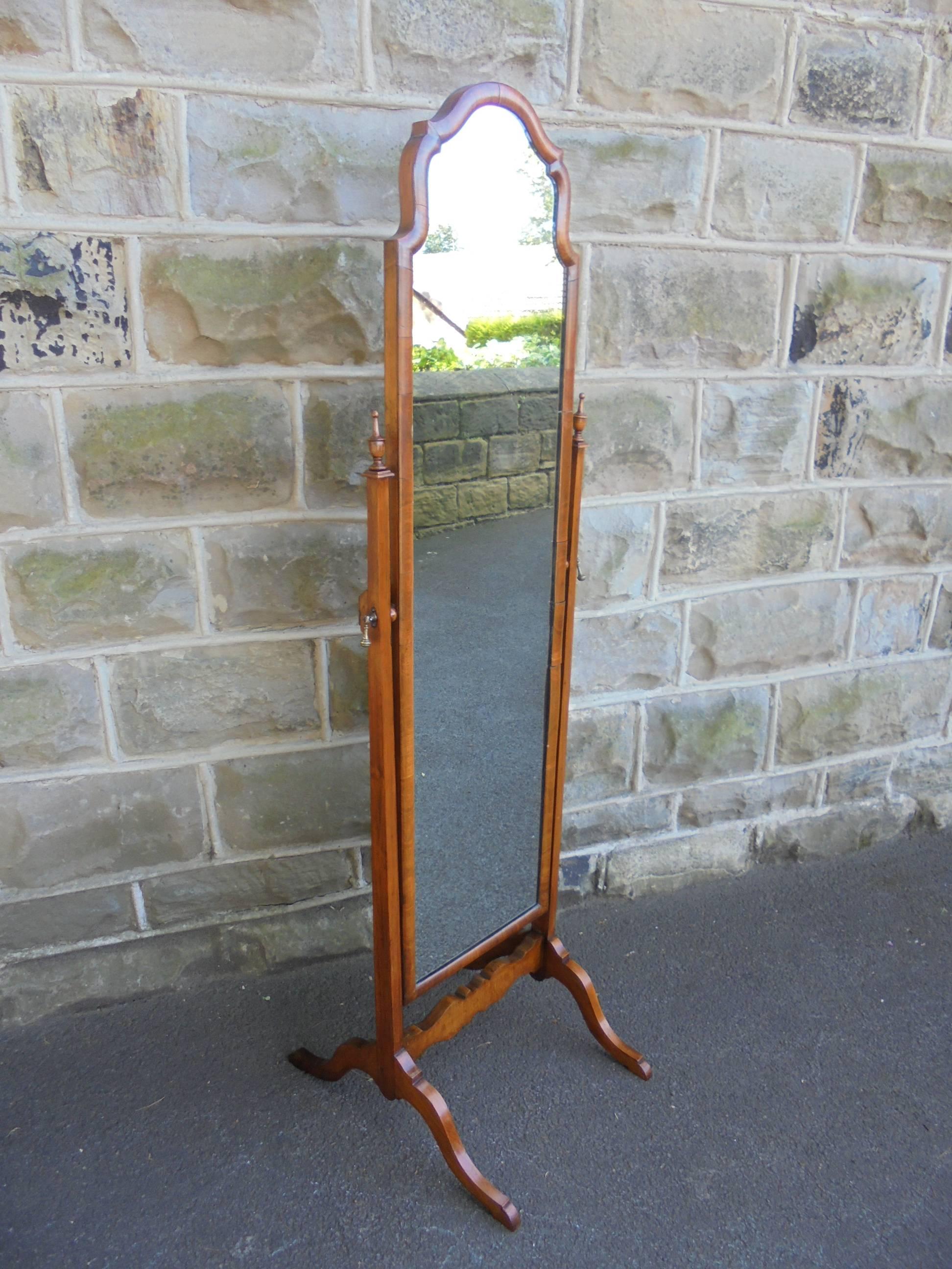 Offered for sale is this nice quality 1920s cheval dressing mirror.

Walnut frame with arched Queen Anne top. Walnut uprights with turned finials at the top, brass drop handles to support the mirror. Standing on shaped walnut legs with a shaped