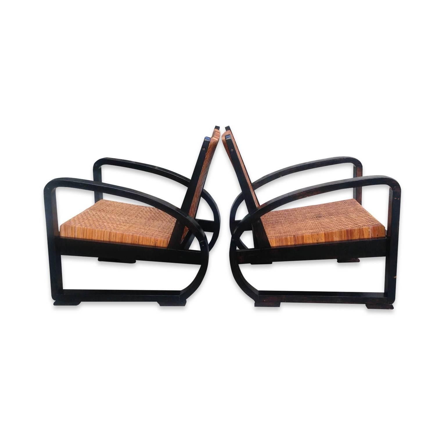 A stylish set of two rattan lounge chairs.
 
The frames have been overpainted black, and show some minor signs of wear, as photographed. The diamond pattern on the seat runs horizontally on two and vertically on one. The rattan itself is in good