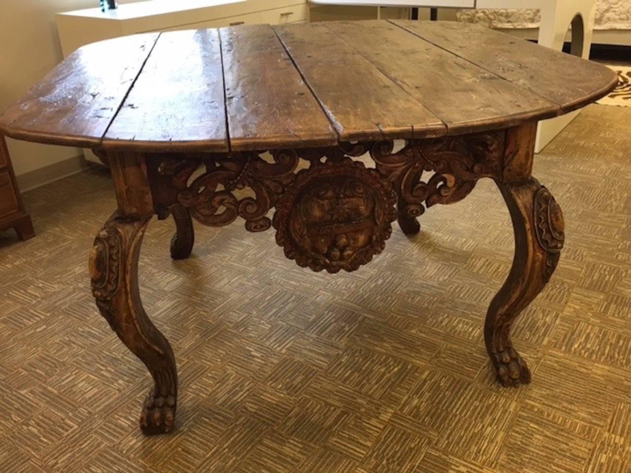 This amazingly detailed vestement table was acquired in Mexico but probably originated in South America. Each of the four sides is intricately carved with a different feature medallion. The original polychrome finish still shows traces of red and