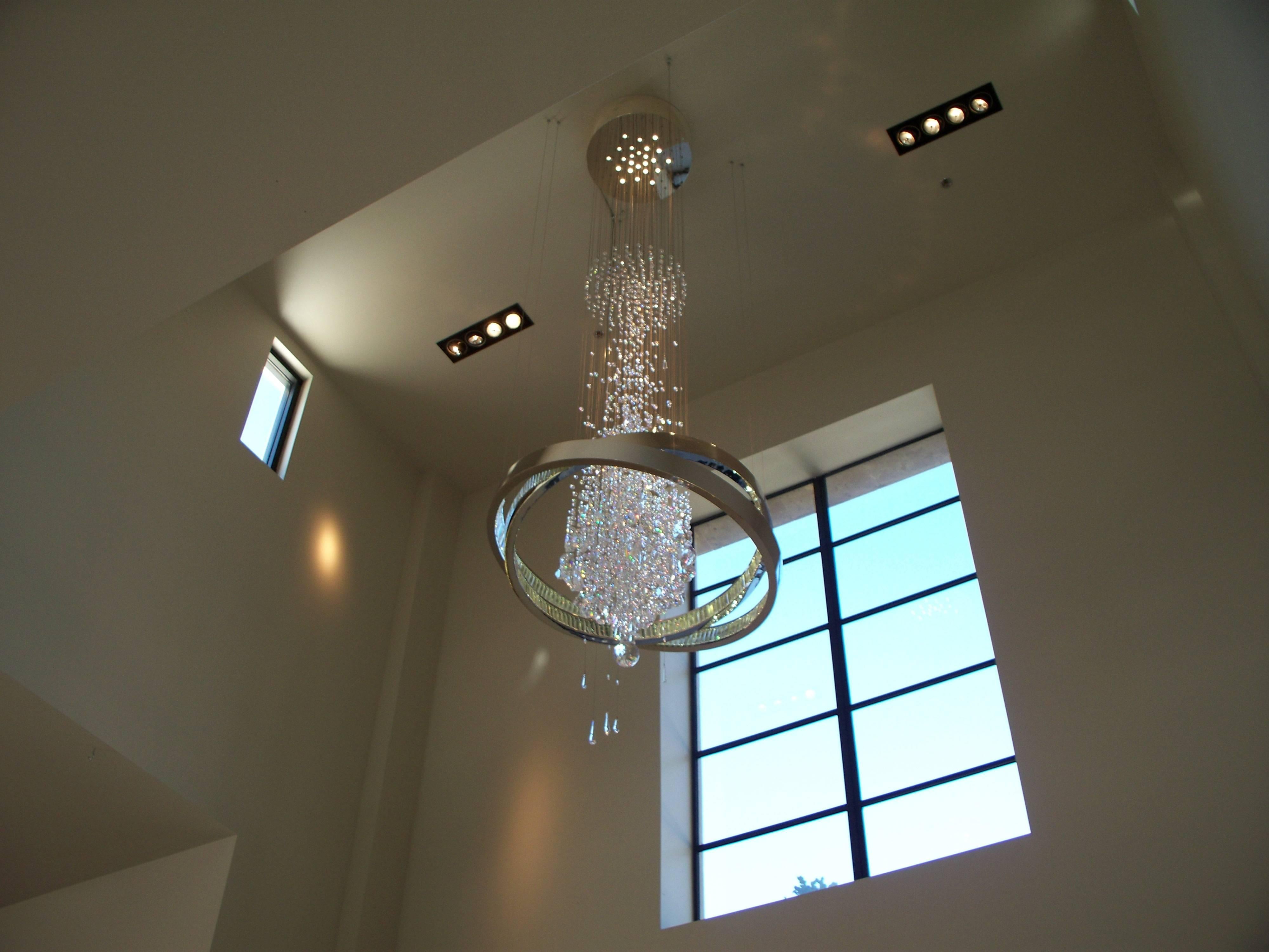 This extraordinarily tall chandelier is comprised of thousands of Swarovski crystals lit from above with halogen bulbs as well as crystal baguettes lining the circles of polished nickel that surround the cascade of crystals all suspended from a