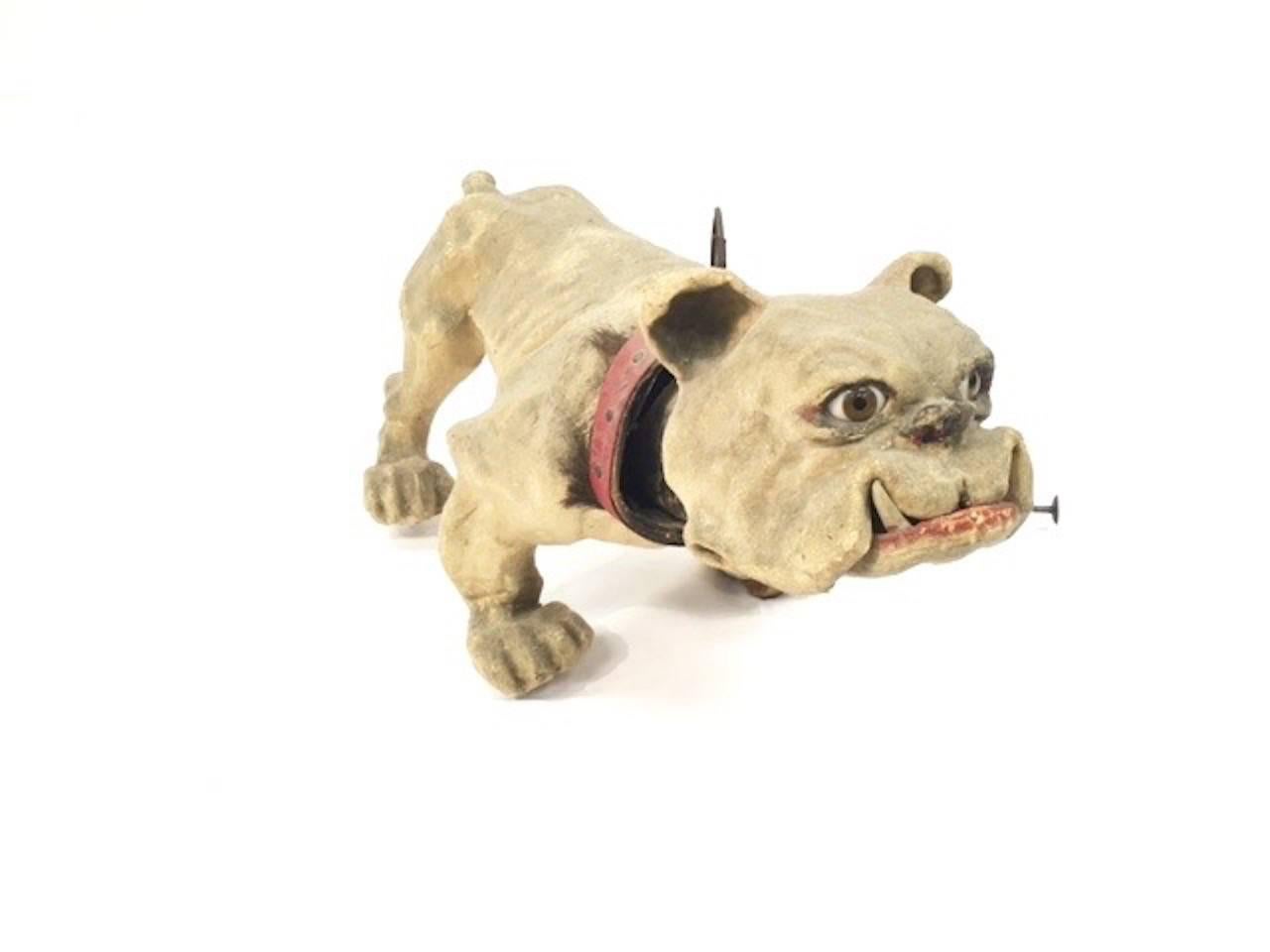 This antique children's toy is mad of papier mâché and has a cord which leads him on his wheels and also makes him growl with his bobbing head. His mouth opens and he follows on the wheels on his feet. The cord also makes him bark. Very old and with