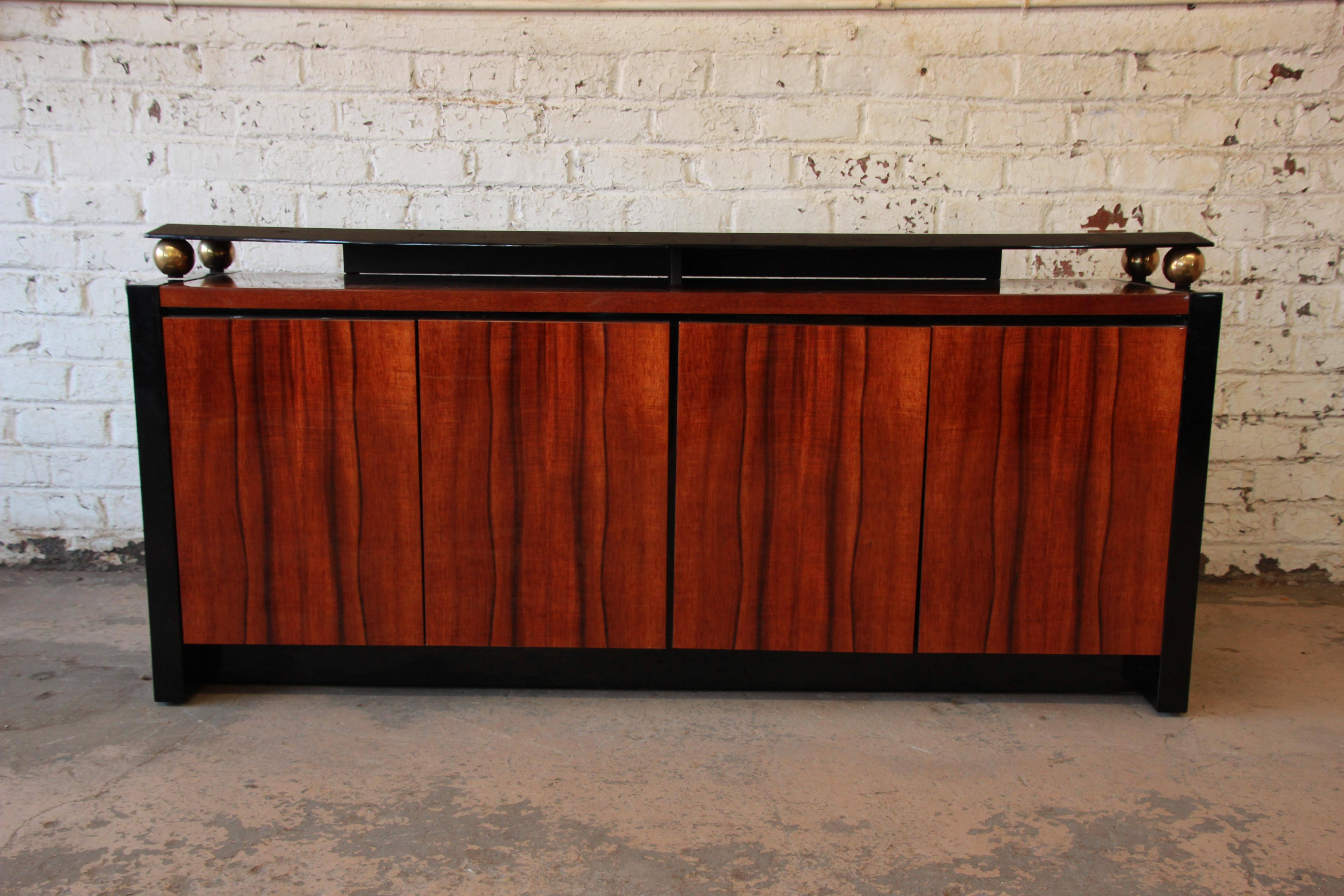 Offering a gorgeous black lacquer and Hawaiian koa wood credenza from the Elan Collection by Henredon. The credenza features stunning and rare koa wood grain and clean, sleek lines. It offers ample room for storage, with three drawers and an