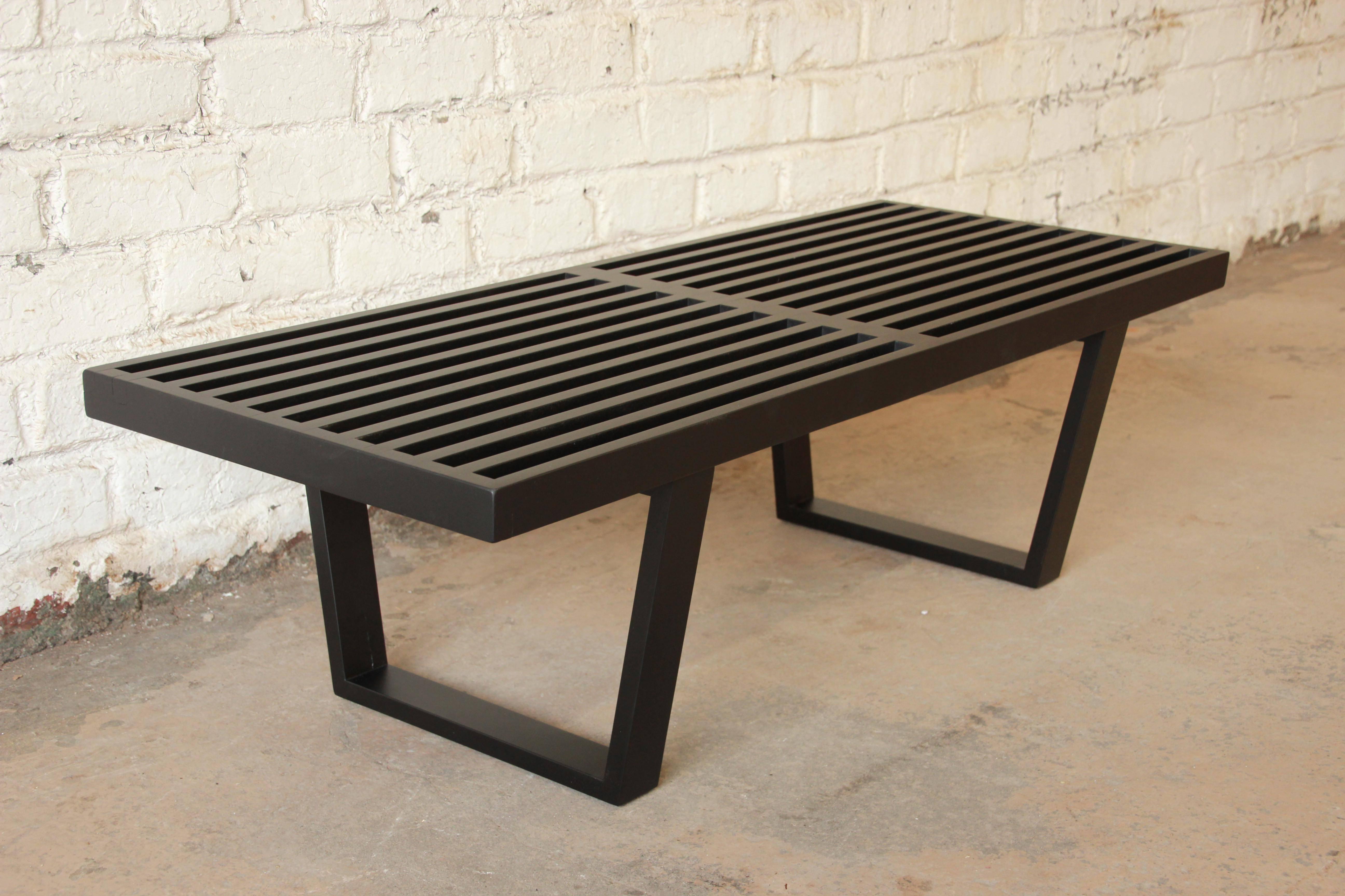 Early platform bench with cushion designed by George Nelson for Herman Miller. The bench has been professionally restored to its original black lacquer finish. The foam on the seat cushion is still in excellent condition, as well as the original
