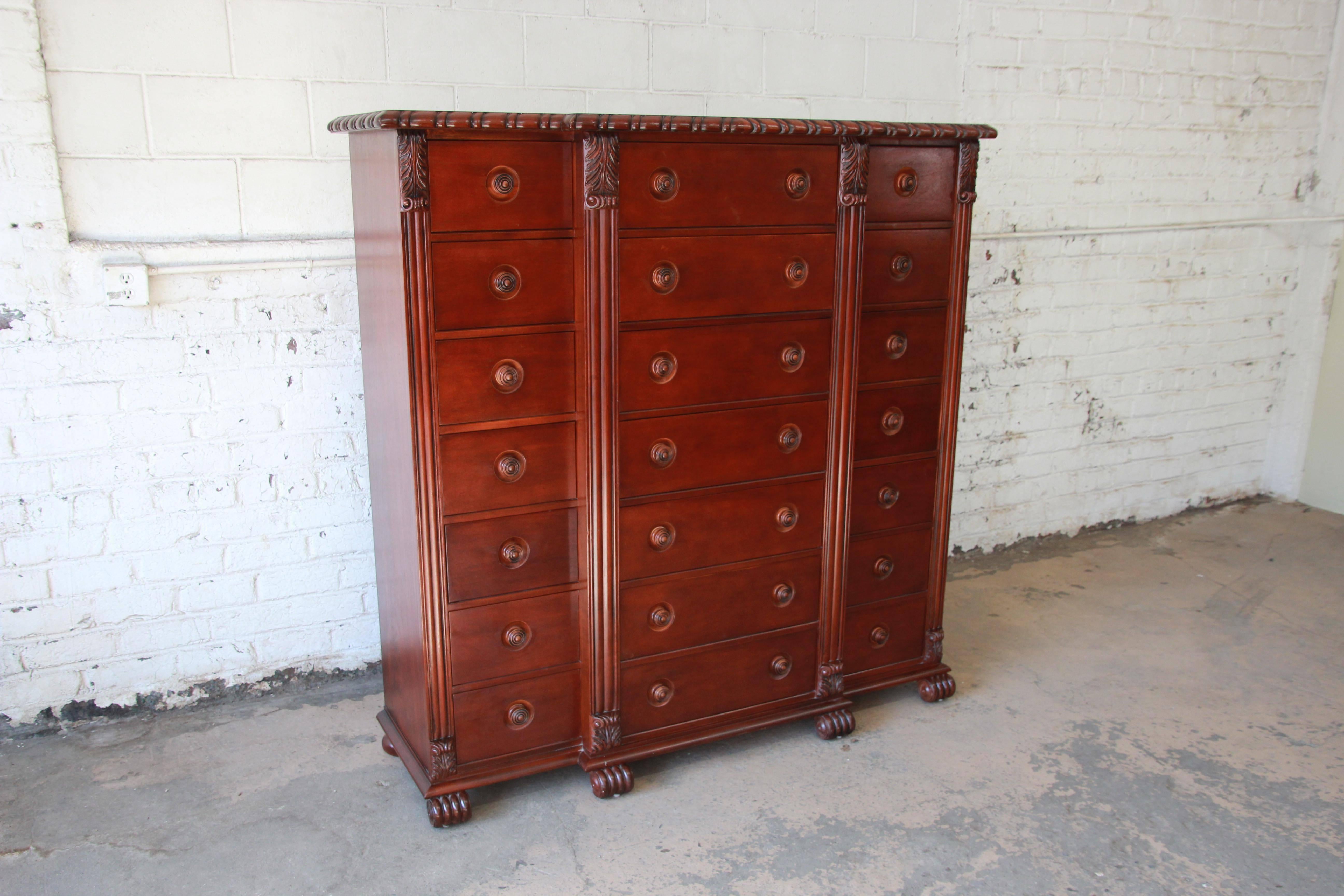 An exceptional and rare 21-drawer British Colonial style mahogany tall chest of drawers by Ralph Lauren. The dresser features stunning mahogany wood grain and beautiful carved wood details, with column style trim that frames all drawers with leaf