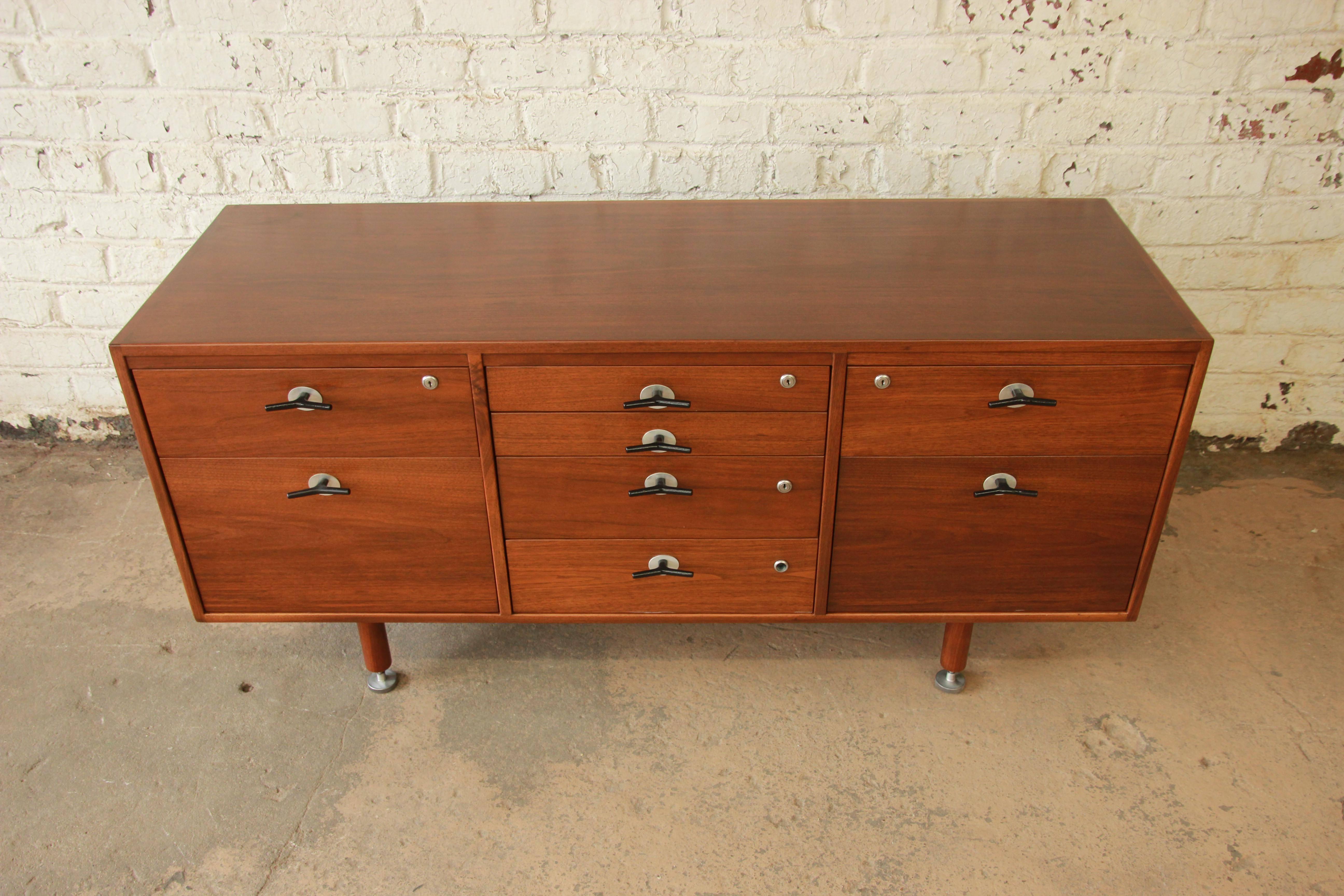 Mid-Century Modern walnut credenza by iconic designer Jens Risom. The credenza has been professionally refinished and has stunning walnut wood grain. It features Risom's unique and rare aluminium 