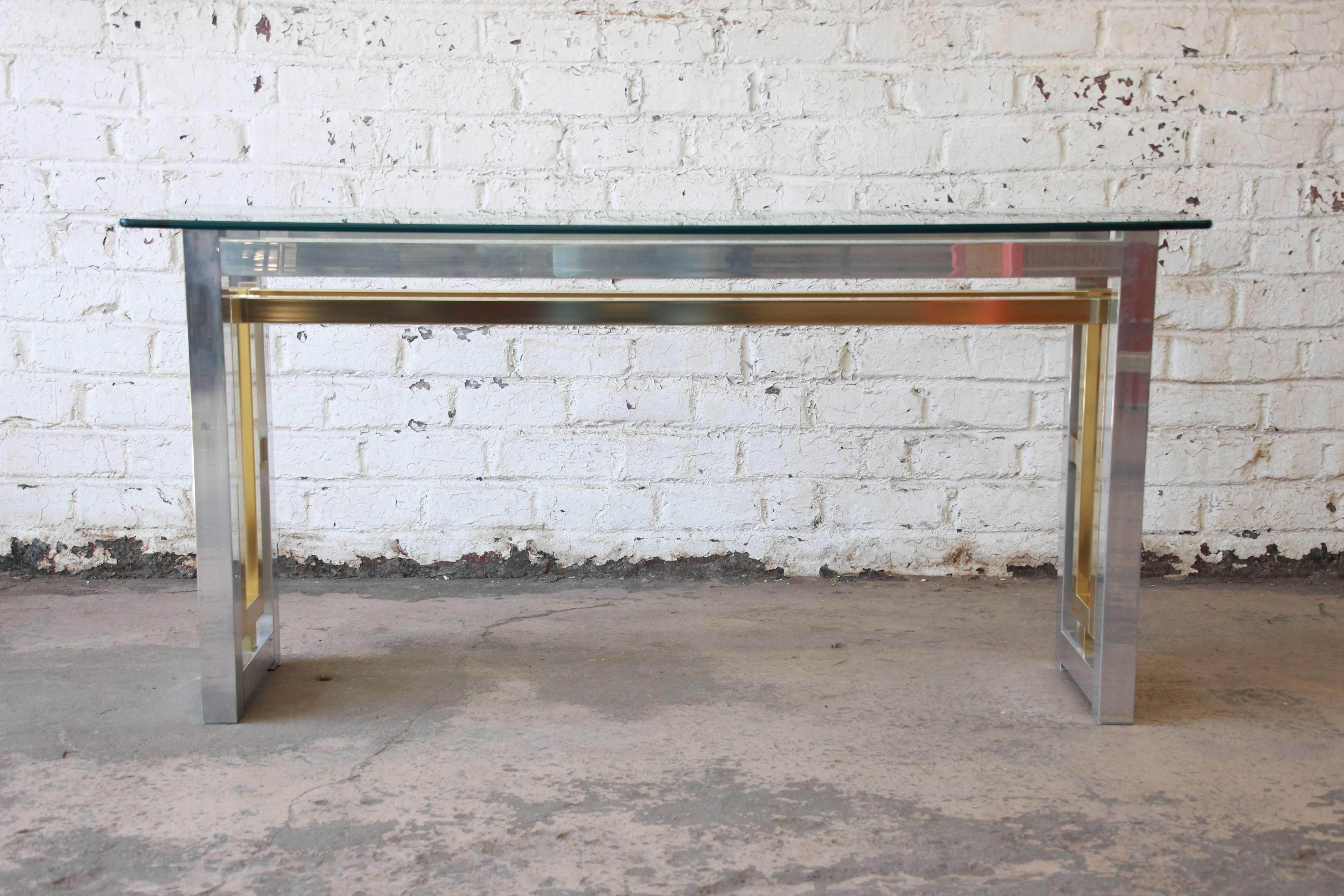 Romeo Rega style console table with thick polished edge glass top and mirrored finish chrome and brass. The piece offers a nice two-toned contrast for an elegant piece in any home.