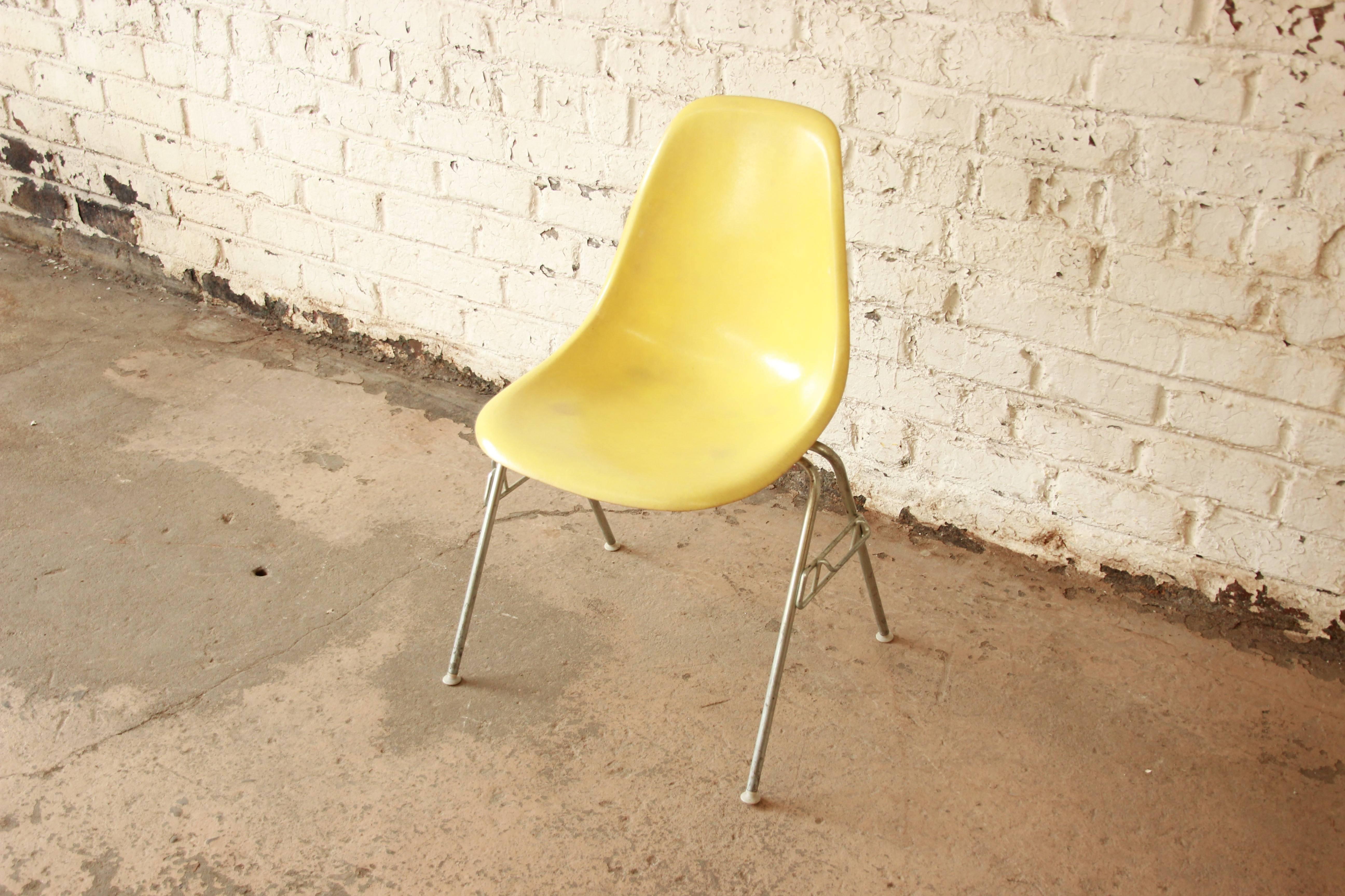 Yellow fiberglass stackable DSS chairs designed by Charles & Ray Eames for Herman Miller. The shell chairs have an unmistakable design and offer a multitude of uses. Chairs have original bases and all shells have embossed Herman Miller logo with