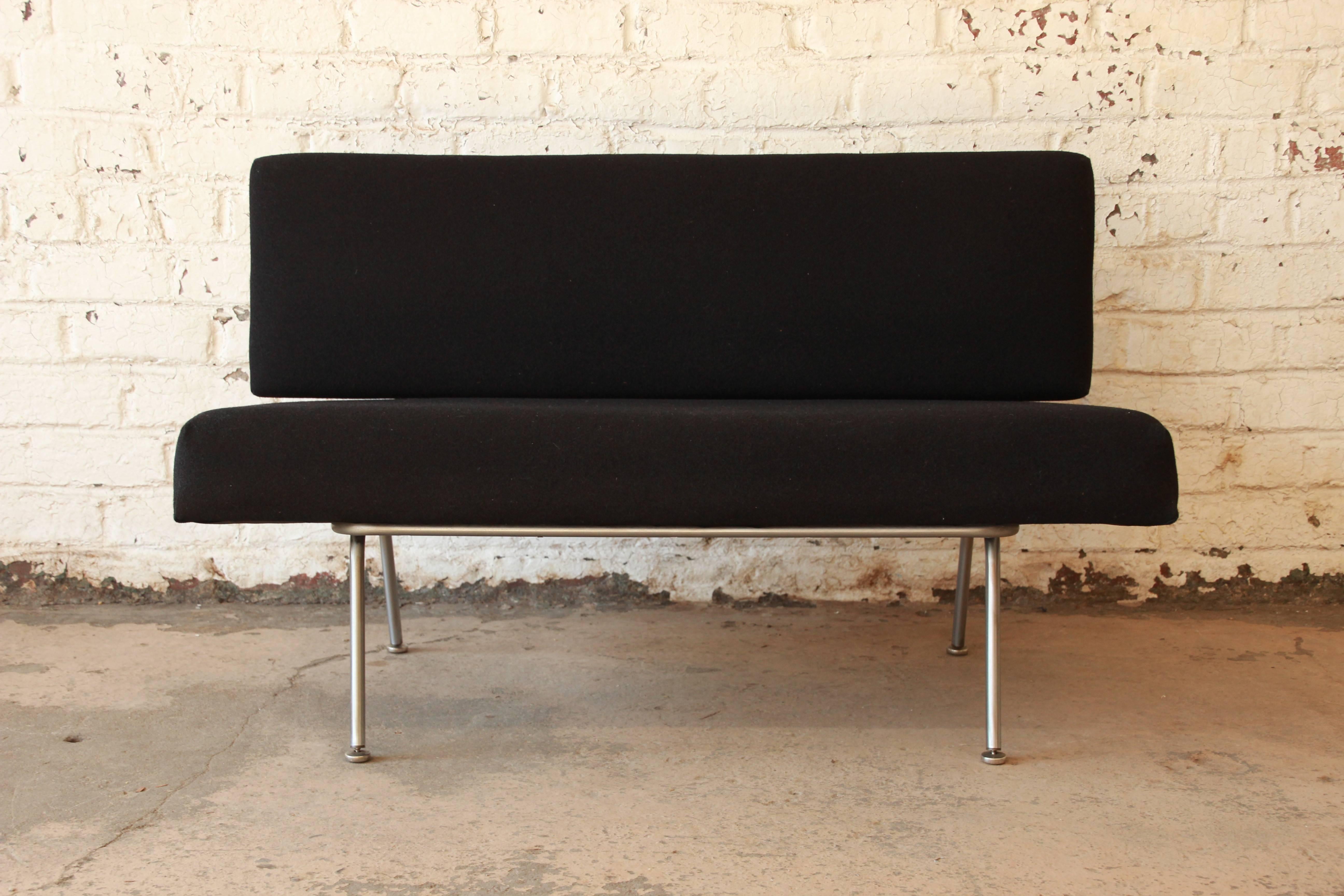 Original model 32 settee designed by Florence Knoll for Knoll Associates, circa 1950. This is a Classic piece of Mid-Century design. It has been newly reupholstered in black wool fabric. The aluminum frame is in great condition. Overall, the settee