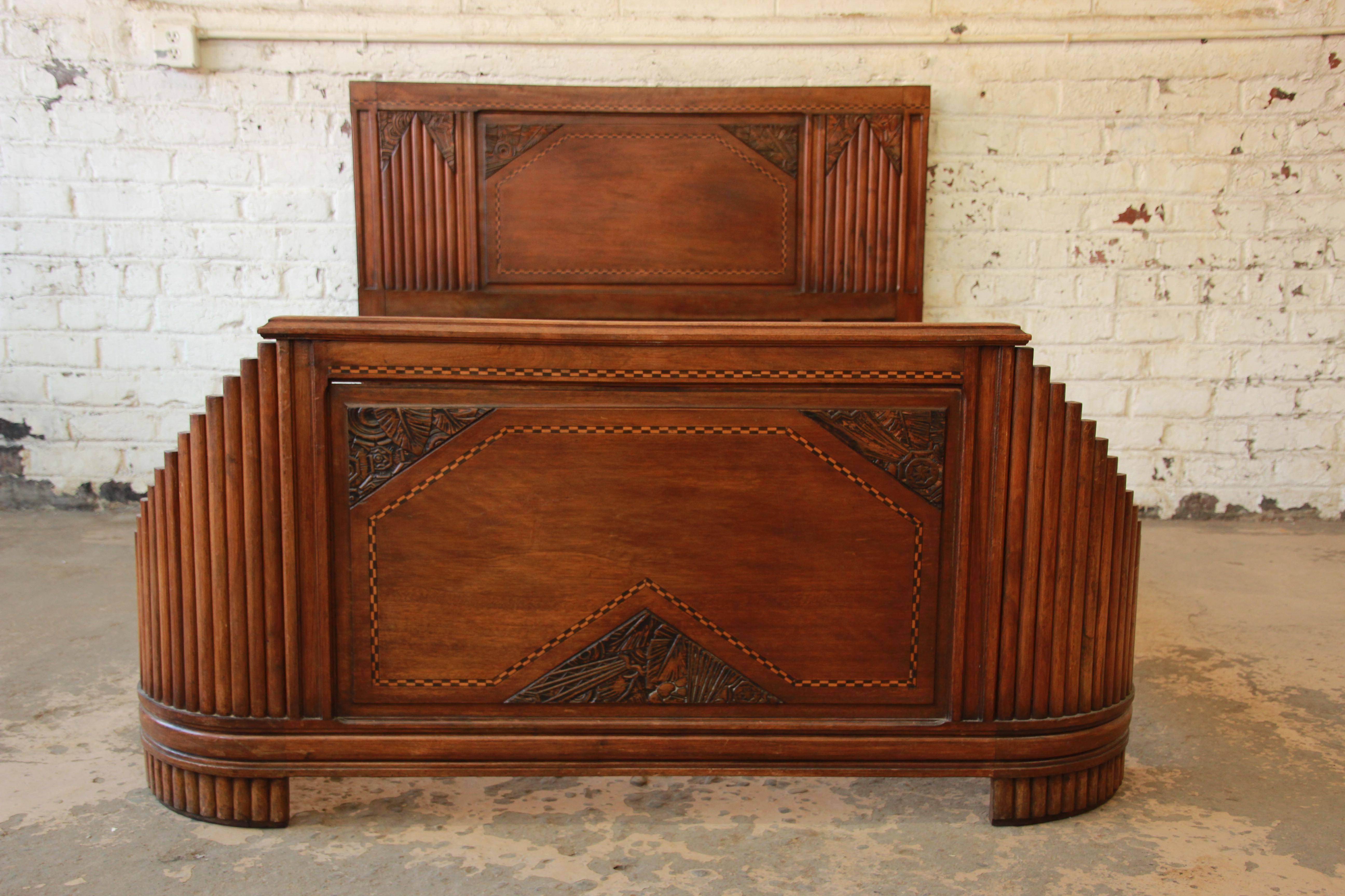 1930s French Art Deco full size bed frame. The frame features gorgeous carved and inlaid wood details. It is very well made from solid walnut. The headboard measures 45