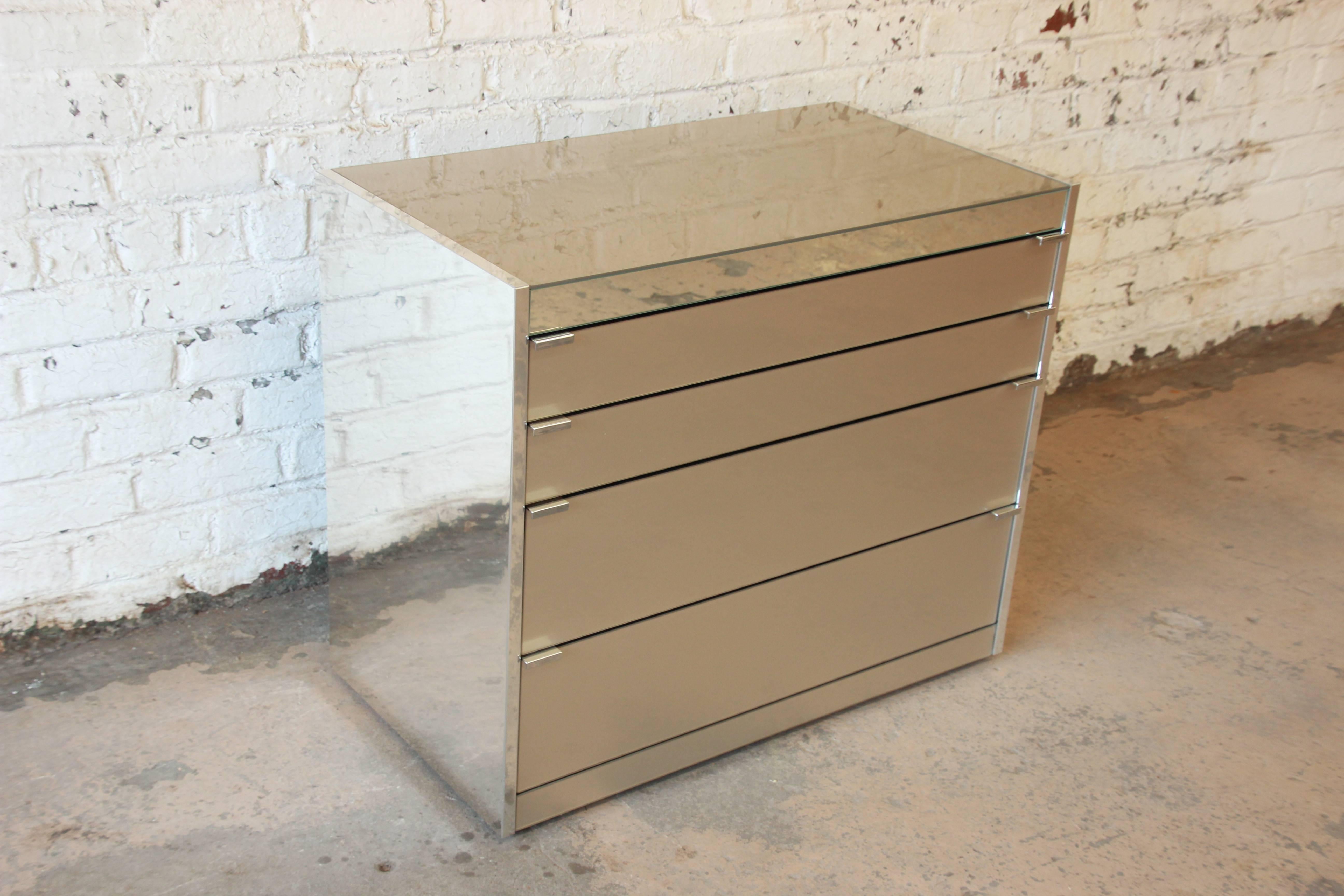 Mid-Century mirrored chest of drawers designed by Guy Barker for Ello. The chest features sleek, Minimalist Mid-Century design and excellent construction from chrome and mirrored glass. It offers good storage, with four graduated drawers. All of the
