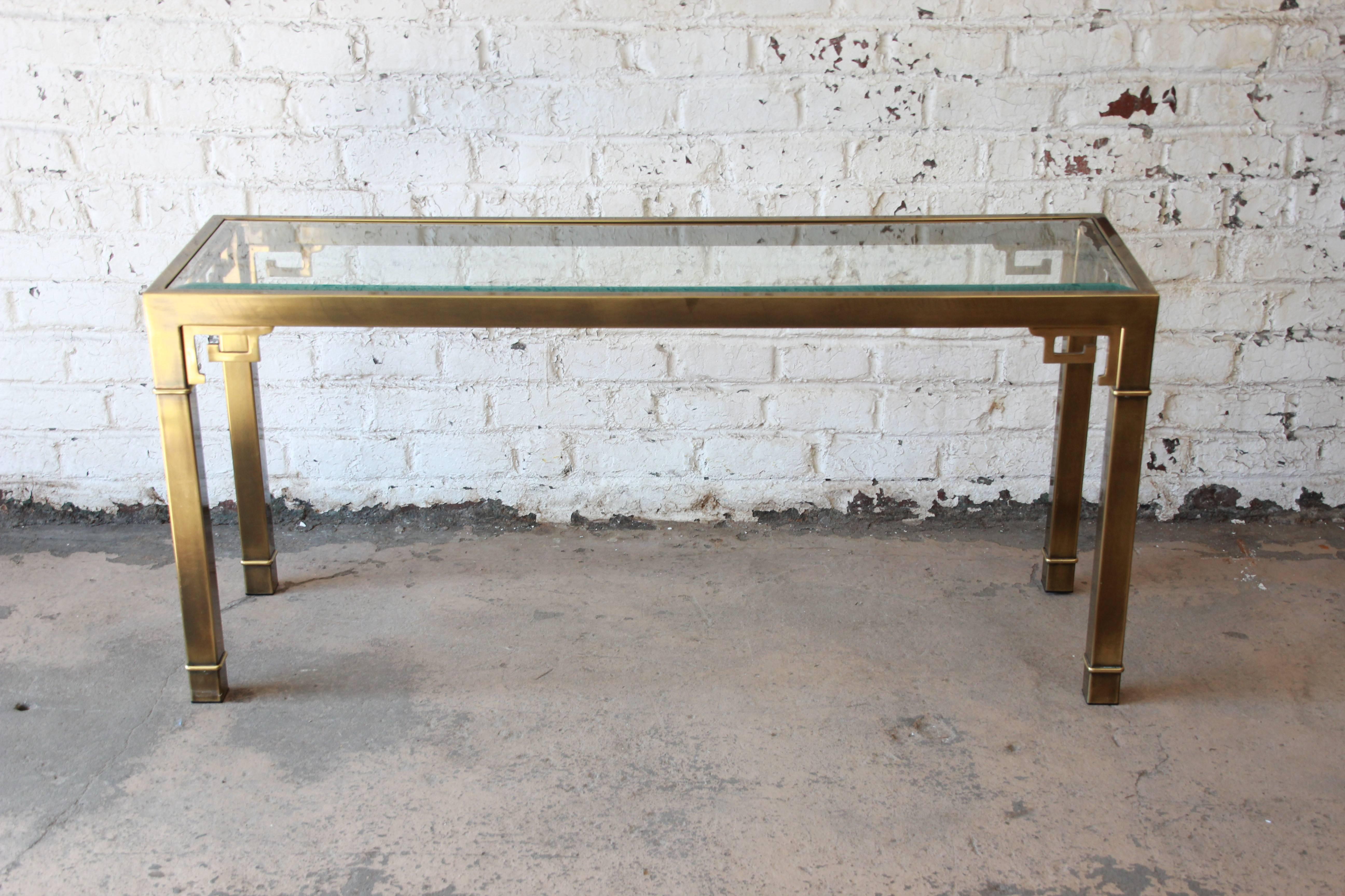 Gorgeous brass console table with Greek key accents by Mastercraft Furniture. The piece has a nice beveled glass top inset into the console. The design elements give the piece a chinoiserie style. The brass is in good condition.
