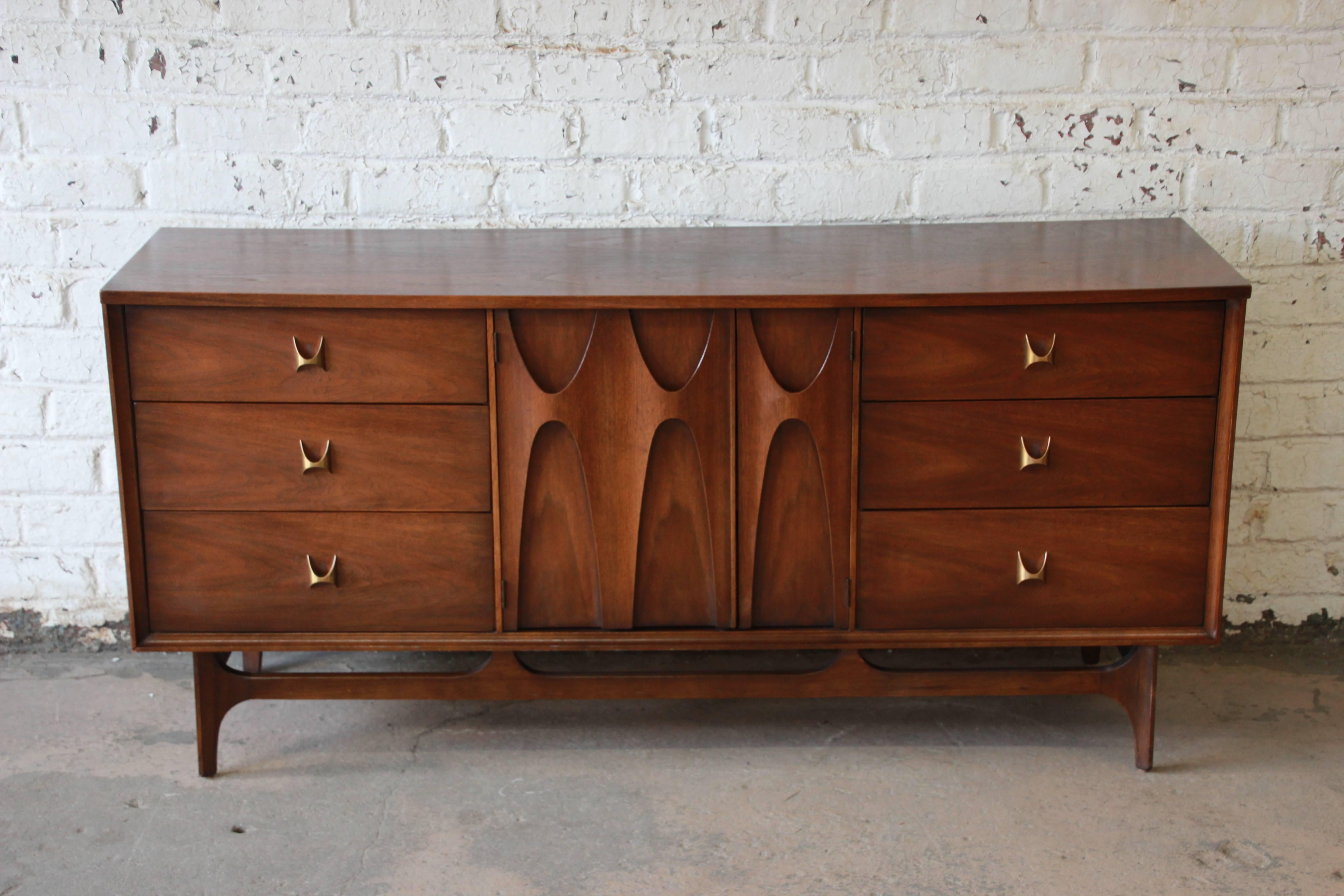 Offering the iconic designed Broyhill Brasilia nine-drawer dresser. The dresser has sculpted arches and original pulls. The centre sculpted cabinet doors open up to three drawers with an additional three large drawers on each side. The dresser is in