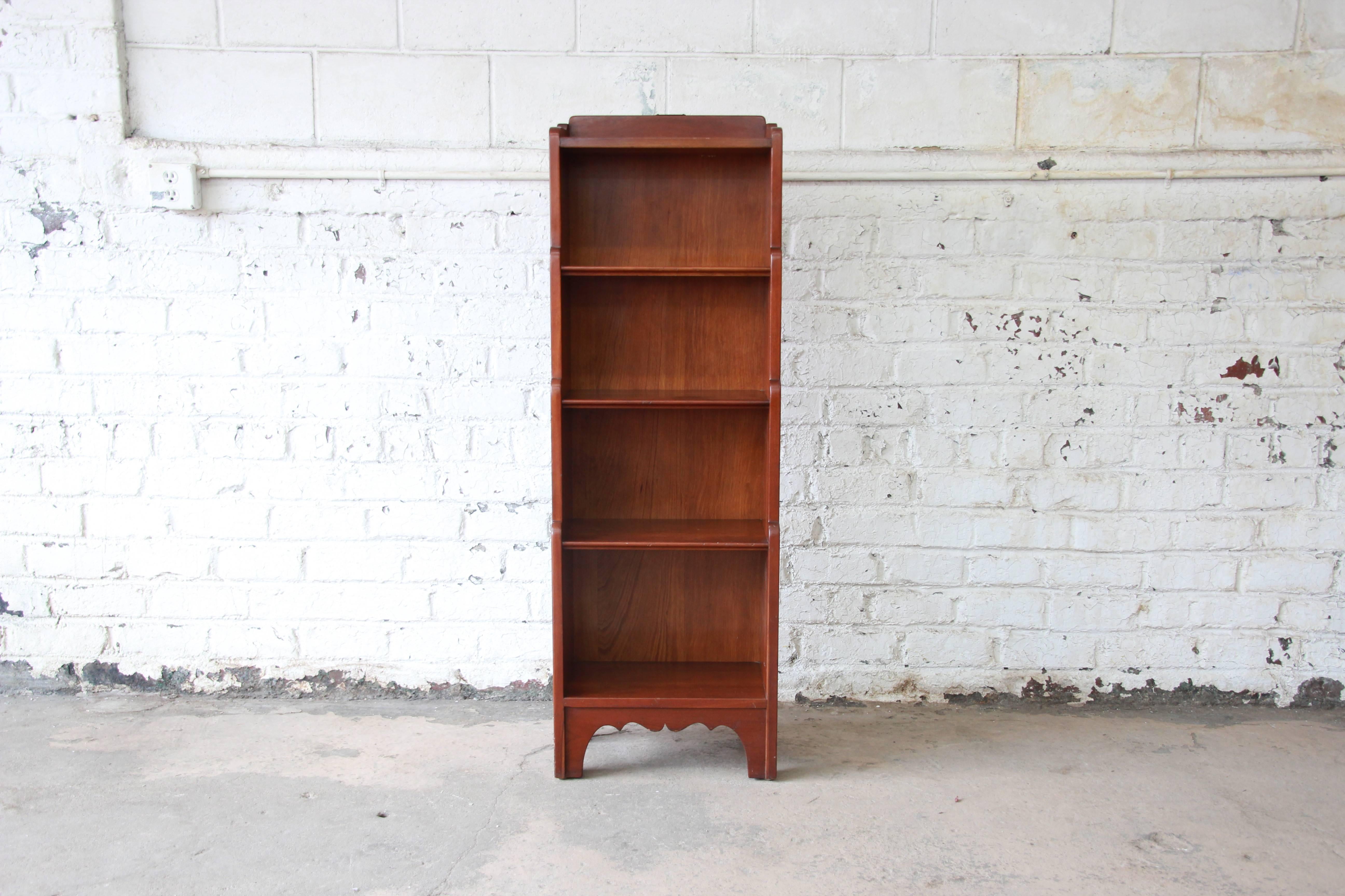 An excellent cherrywood graduated bookcase designed by Leopold Stickley. The bookcase features beautiful cherrywood grain and solid wood construction. Original Stickley branded label and Leopold Stickley paper label are present. The label is date