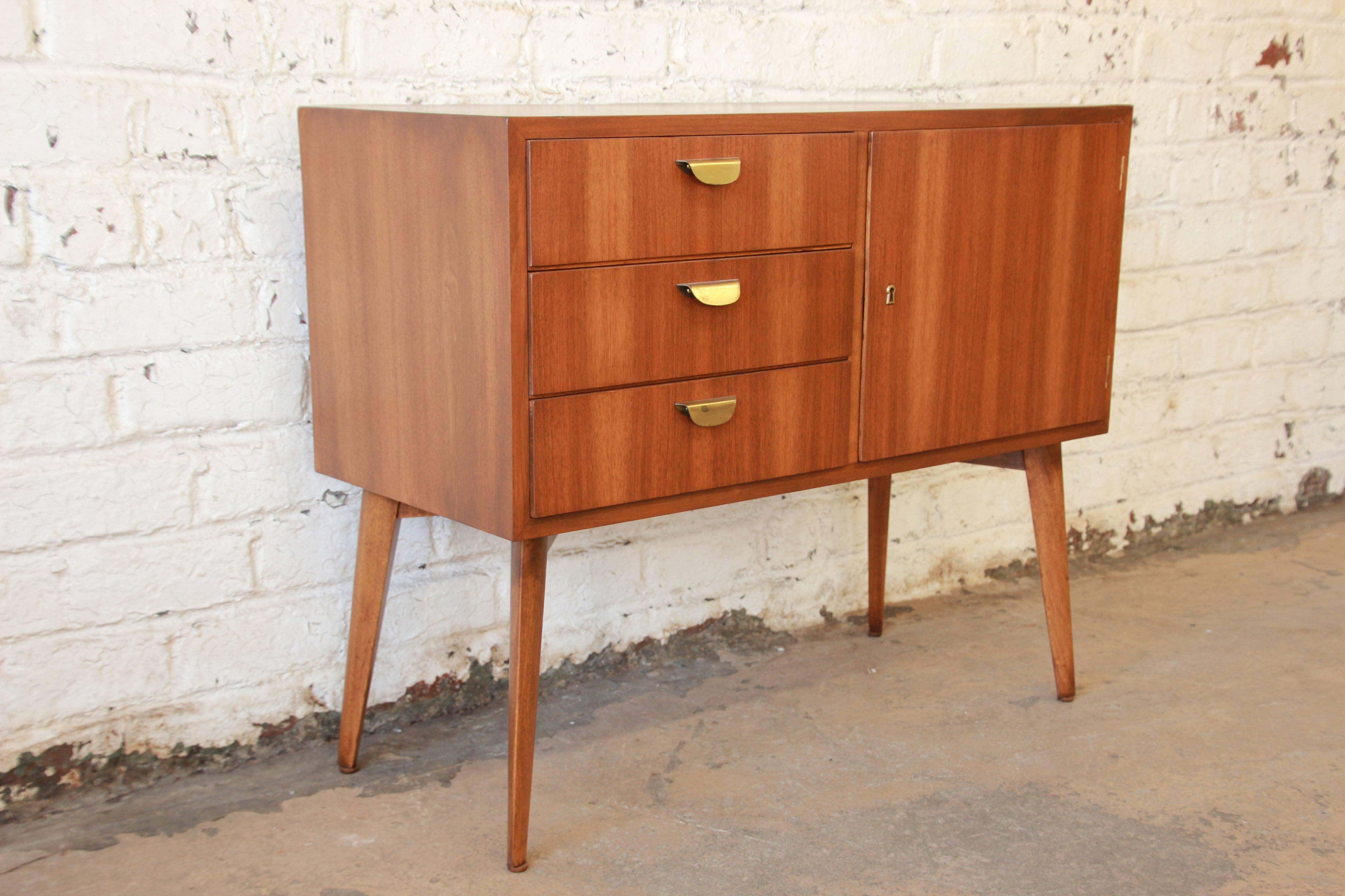 A rare and stunning Mid-Century Modern credenza or dresser designed in Germany by Helmut Magg for WK Möbel. The credenza features clean, sleek Mid-Century Modern lines with Minimalist design and a beautiful walnut wood grain. It offers ample room