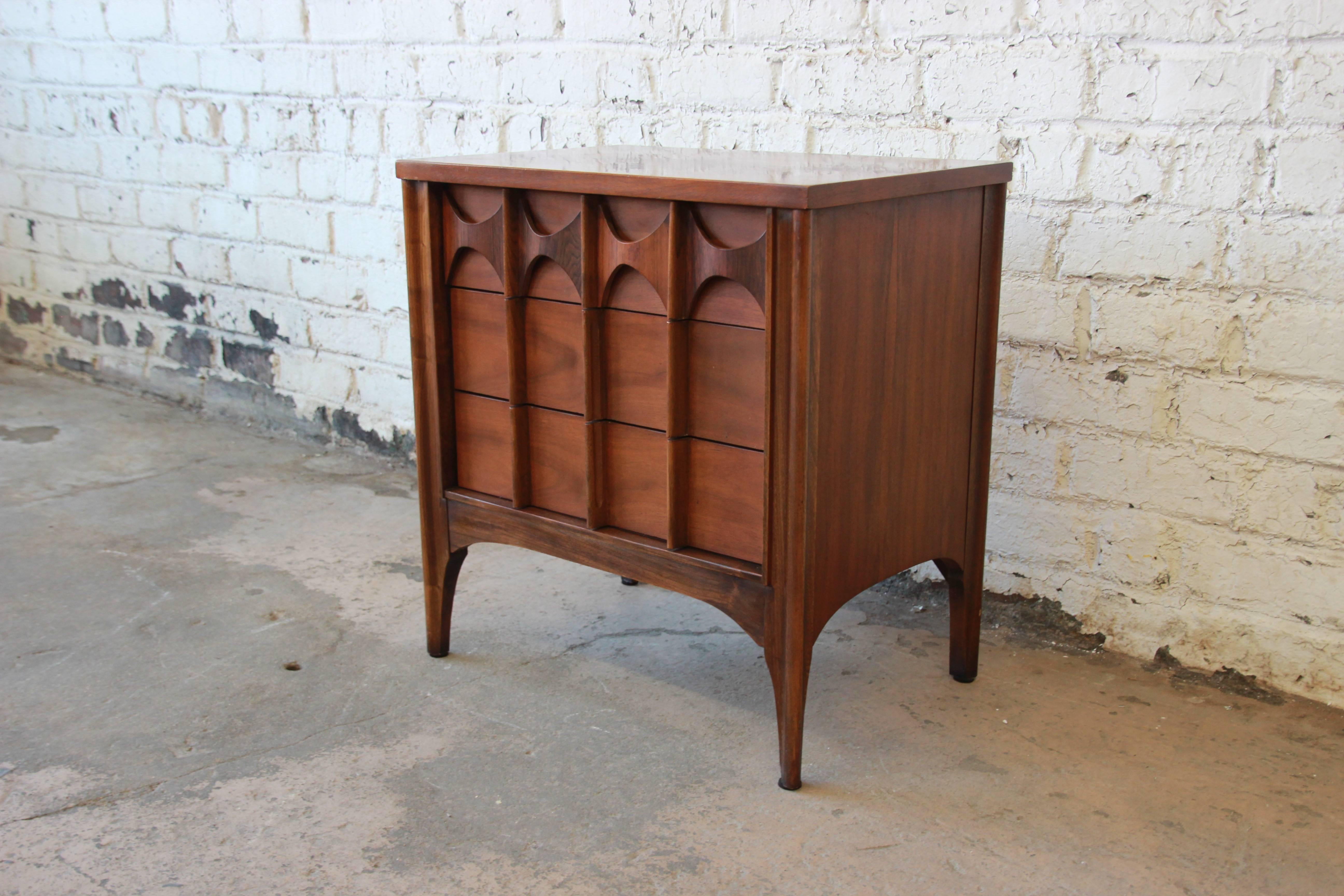A beautiful Mid-Century Modern sculpted walnut and rosewood nightstand or end table from the 
