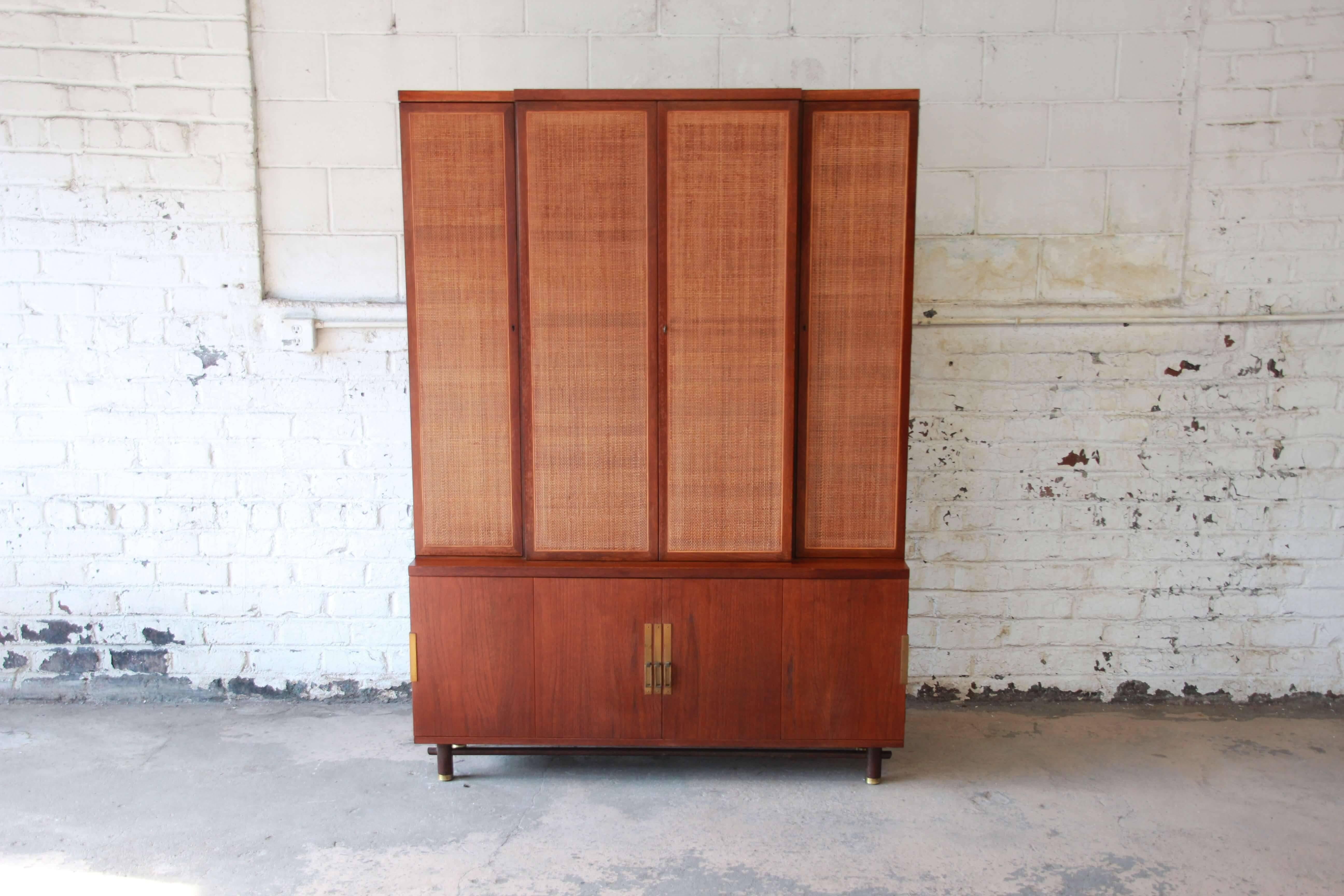 Offering an exceptional woven front Mid-Century Modern wall unit cabinet by Baker Furniture. The cabinets centre doors open up to three adjustable shelves for storage. On each side there is an additional cabinet door that opens up to a smaller