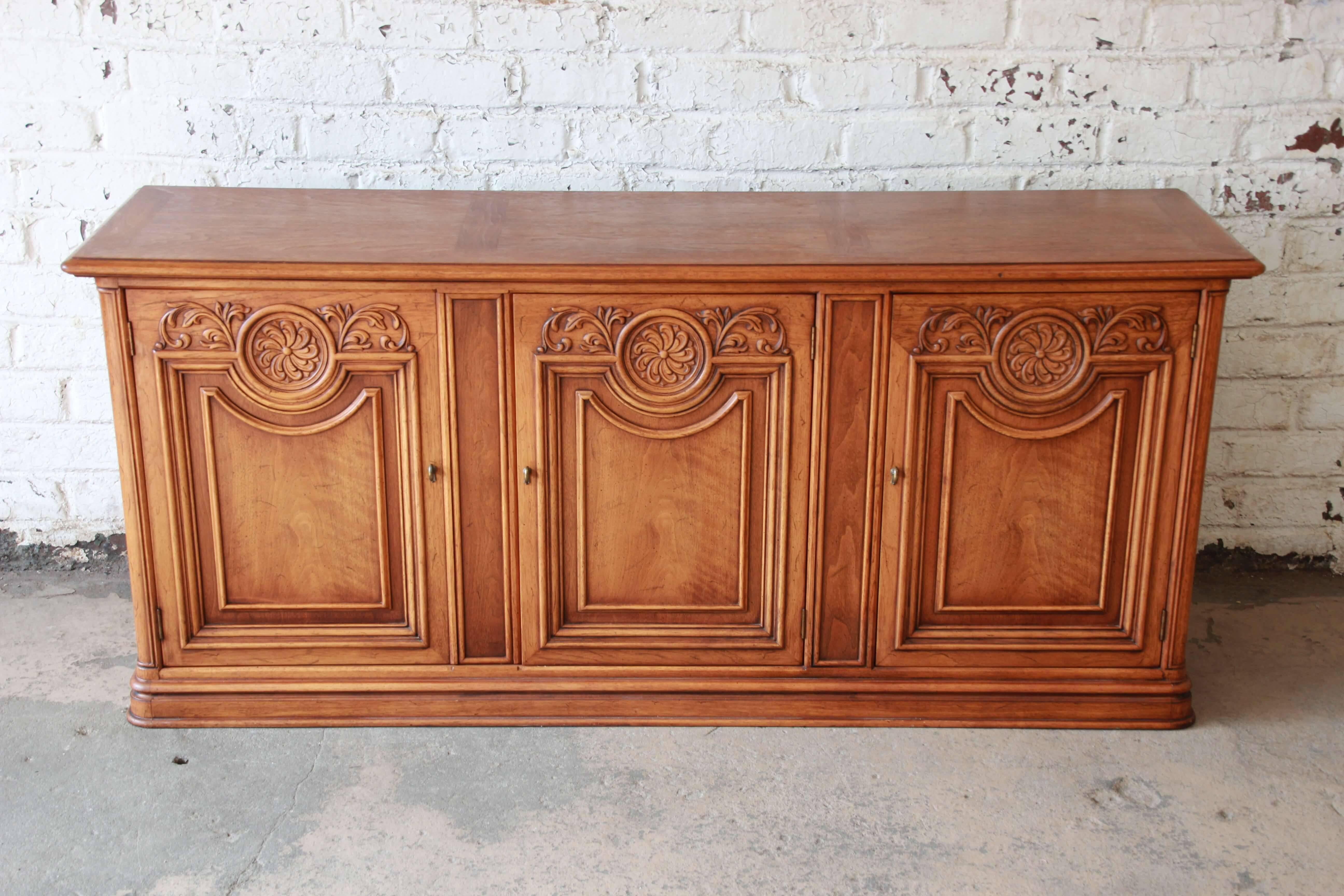 Offering a very nice French Country style sideboard by Henredon. The oak sideboard has nice French details with a plinth base. The right cabinet doors opens to an adjustable shelf. The left side doors open up to three large drawers for ample room