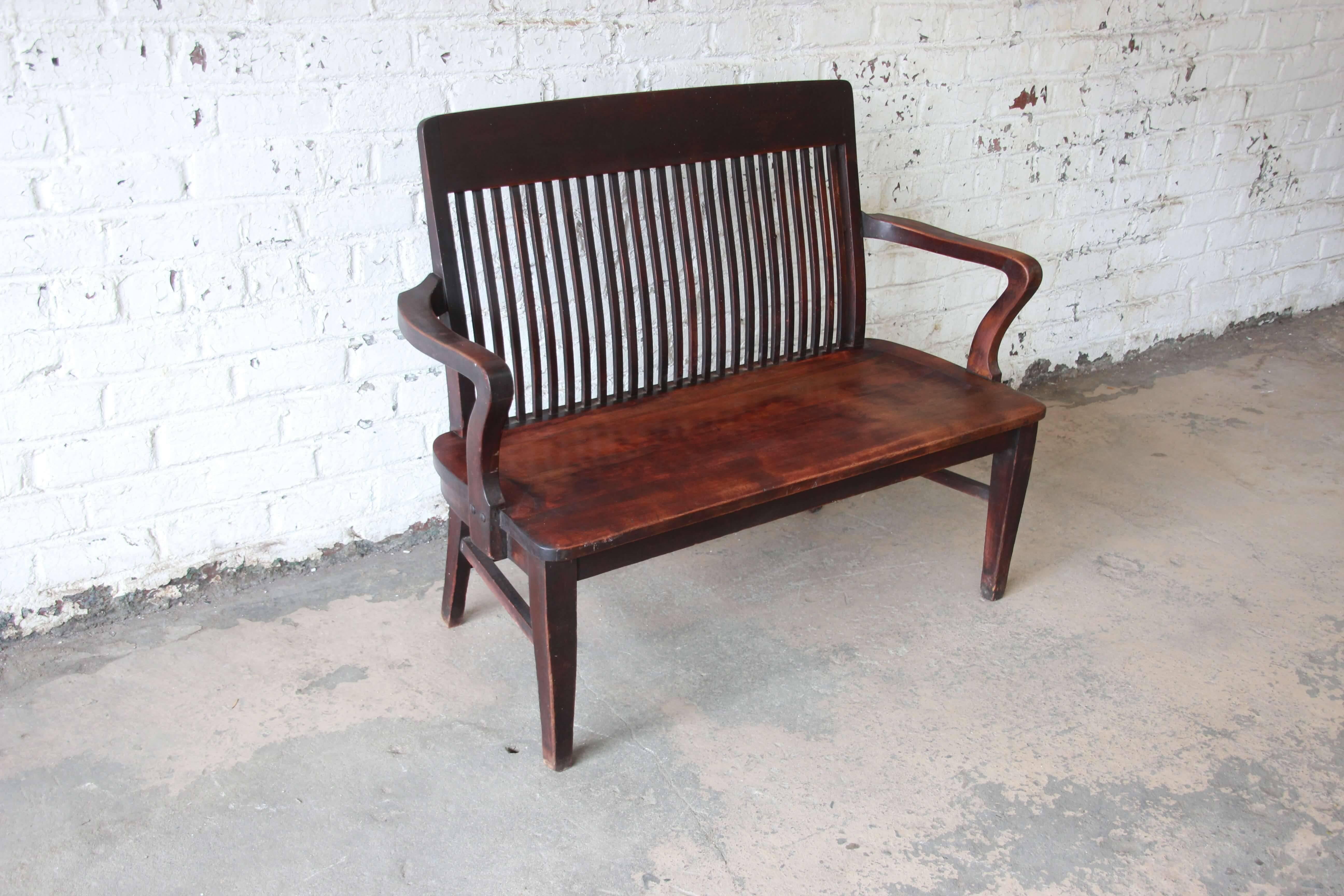 Offering a fantastic mahogany banker's bench from the early 1900s. The bench was manufactured by the Milwaukee Chair Co. It sits comfortably and the back slats and joinery is sturdy. It has a nice patina and would serve in a multitude of different
