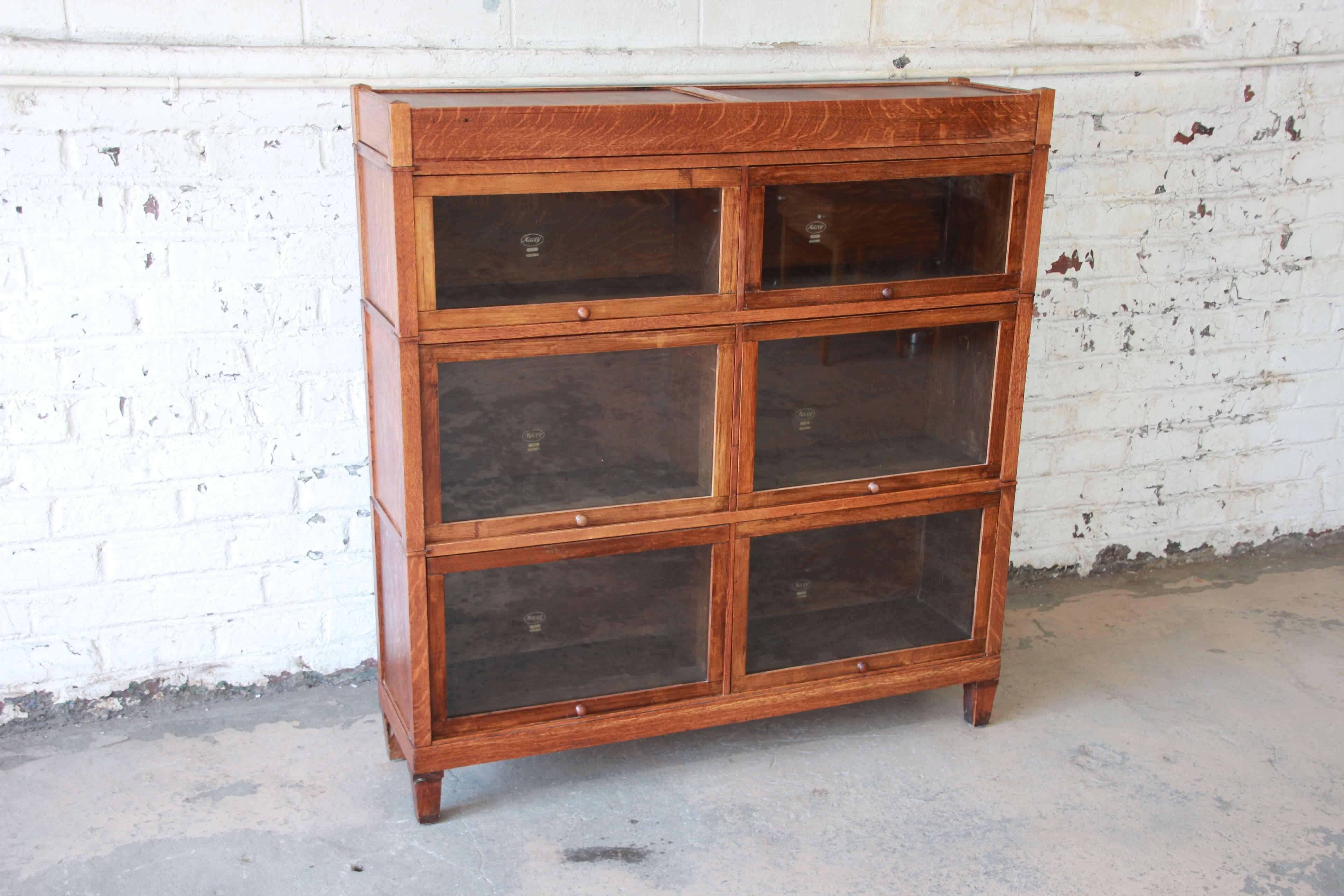 Offering a very nice antique oak double barrister bookcase by Macey. The three-stack bookcase features graduated cases each with its own glass-front door. The bookcase offers lots of room for storage and is sturdy. Very minor wear from age and use