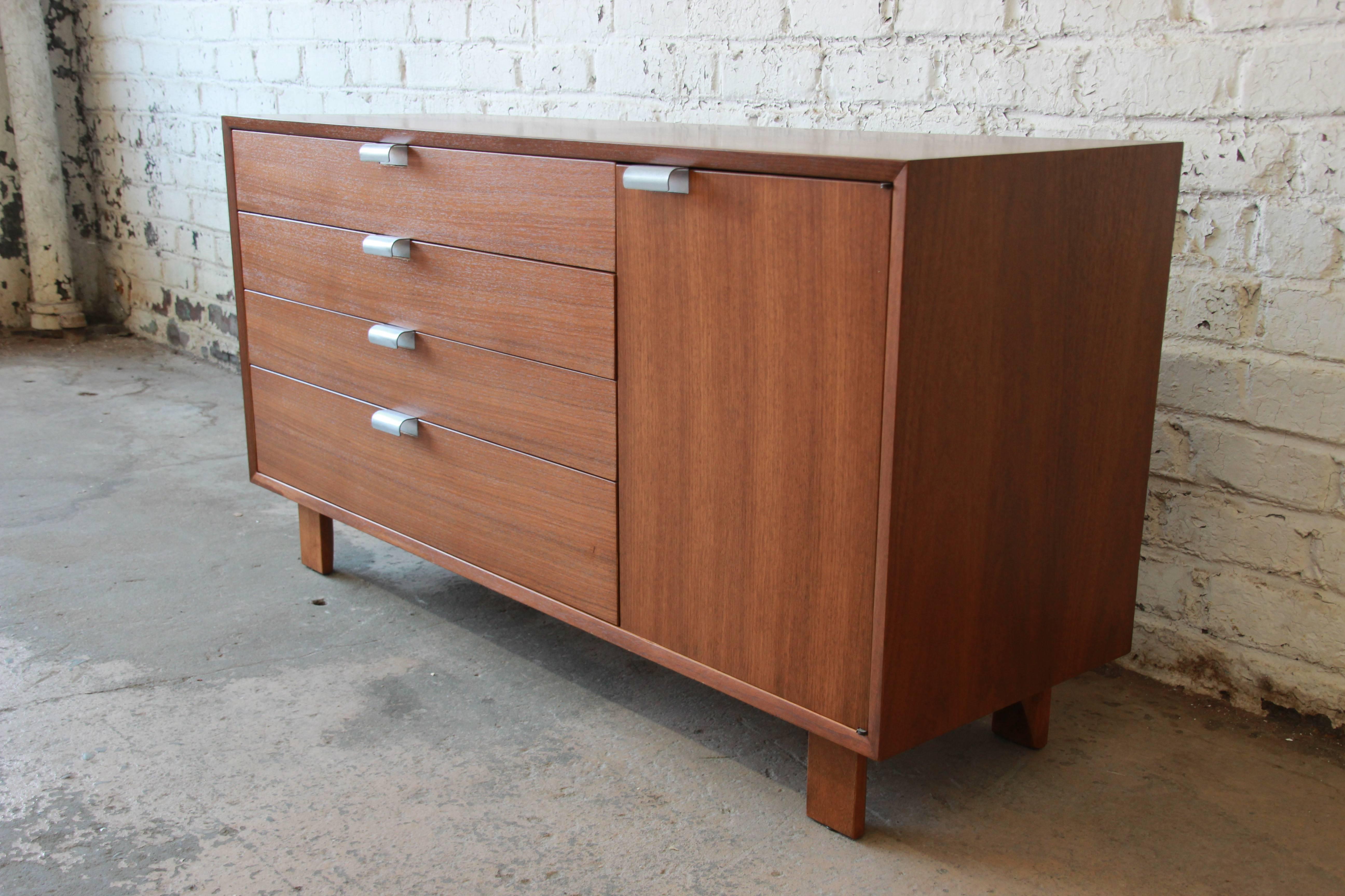 An outstanding Mid-Century Modern credenza or dresser designed by George Nelson for Herman Miller. The credenza features gorgeous primavera wood grain and sleek Mid-Century design. It offers ample room for storage, with four deep dovetailed drawers