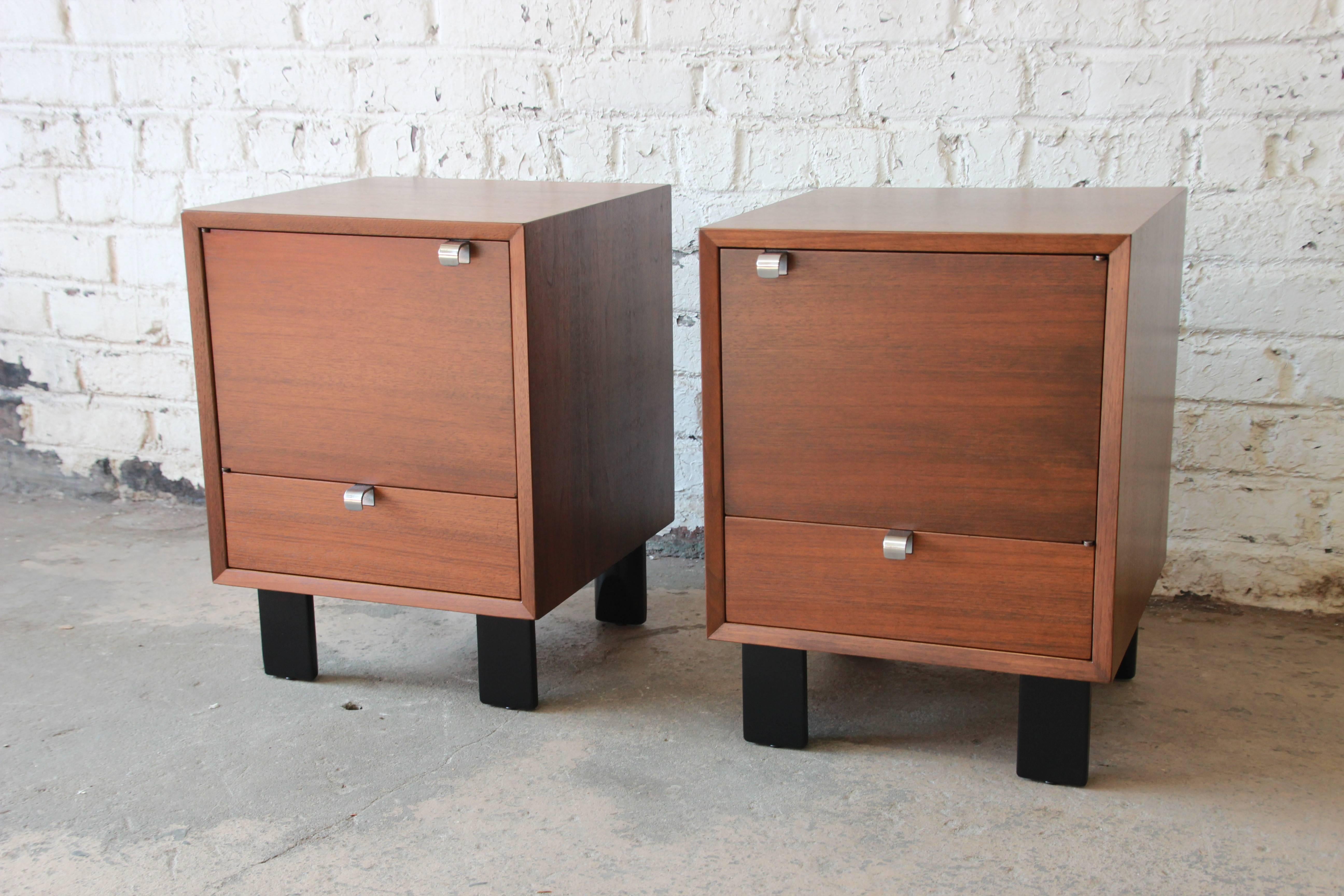 An outstanding and rare pair of Mid-Century Modern nightstands by iconic designer George Nelson for Herman Miller. The nightstands feature beautiful combed oakwood grain and black lacquered legs. They offer a sleek and stylish Mid-Century design.