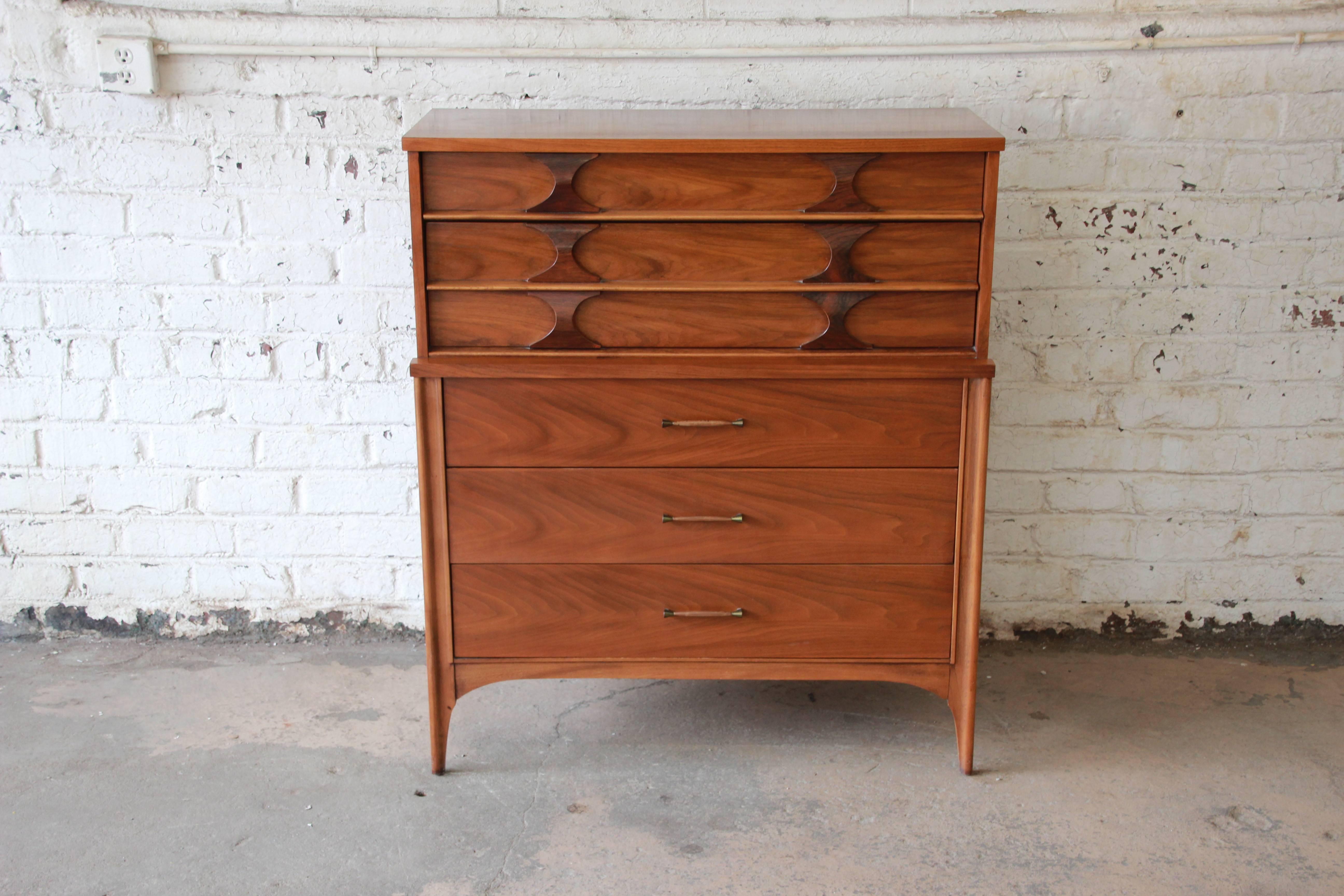 Offering a very nice Kent Coffey Perspecta Mid-Century Modern highboy dresser. The dresser has a stunning walnut wood grain and great midcentury lines. The top portion of the dresser has two drawers with rosewood pulls and a divider for