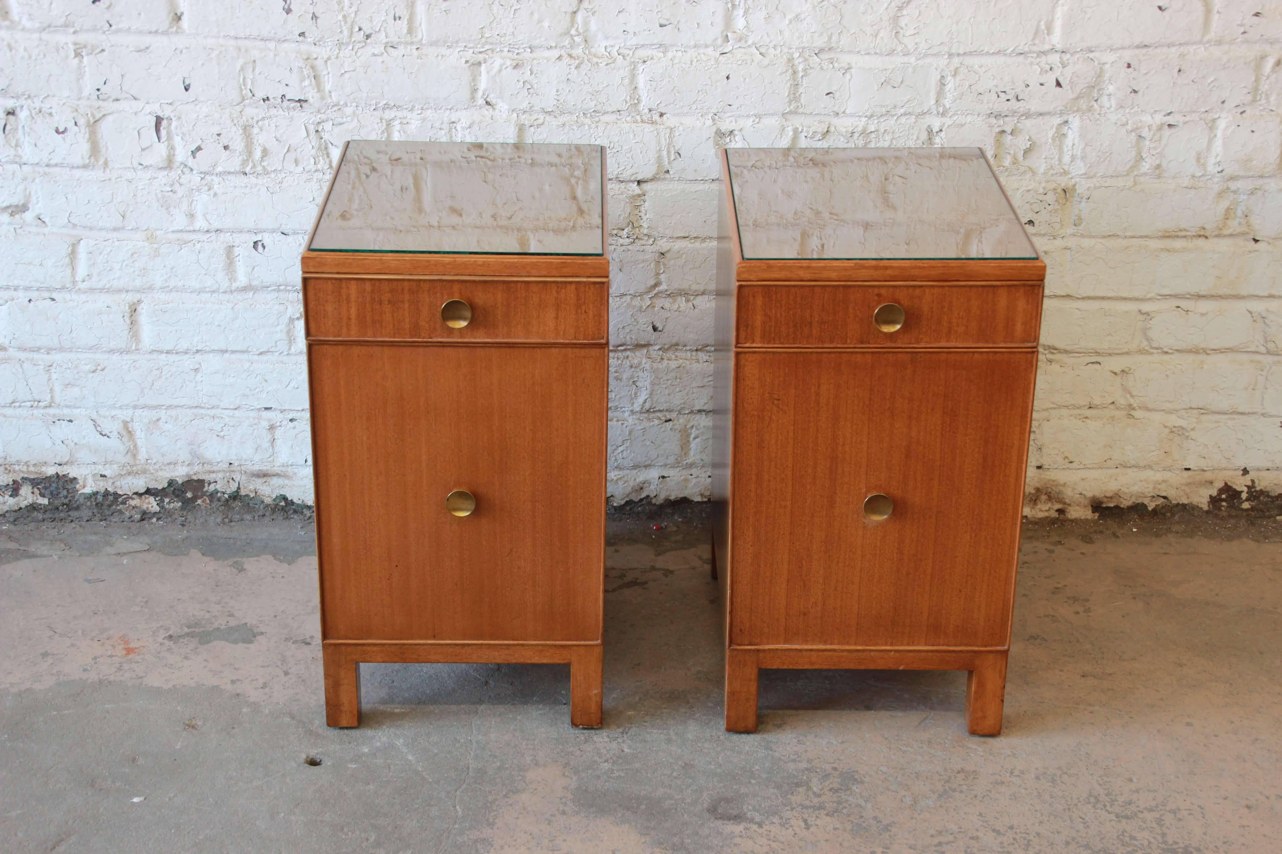 Offering a very nice original condition pair of Dunbar nightstand by Edward Wormley. This set was designed back in 1941 and is in great original condition. The top of the nightstands have inset glass tops which are great attributes for any