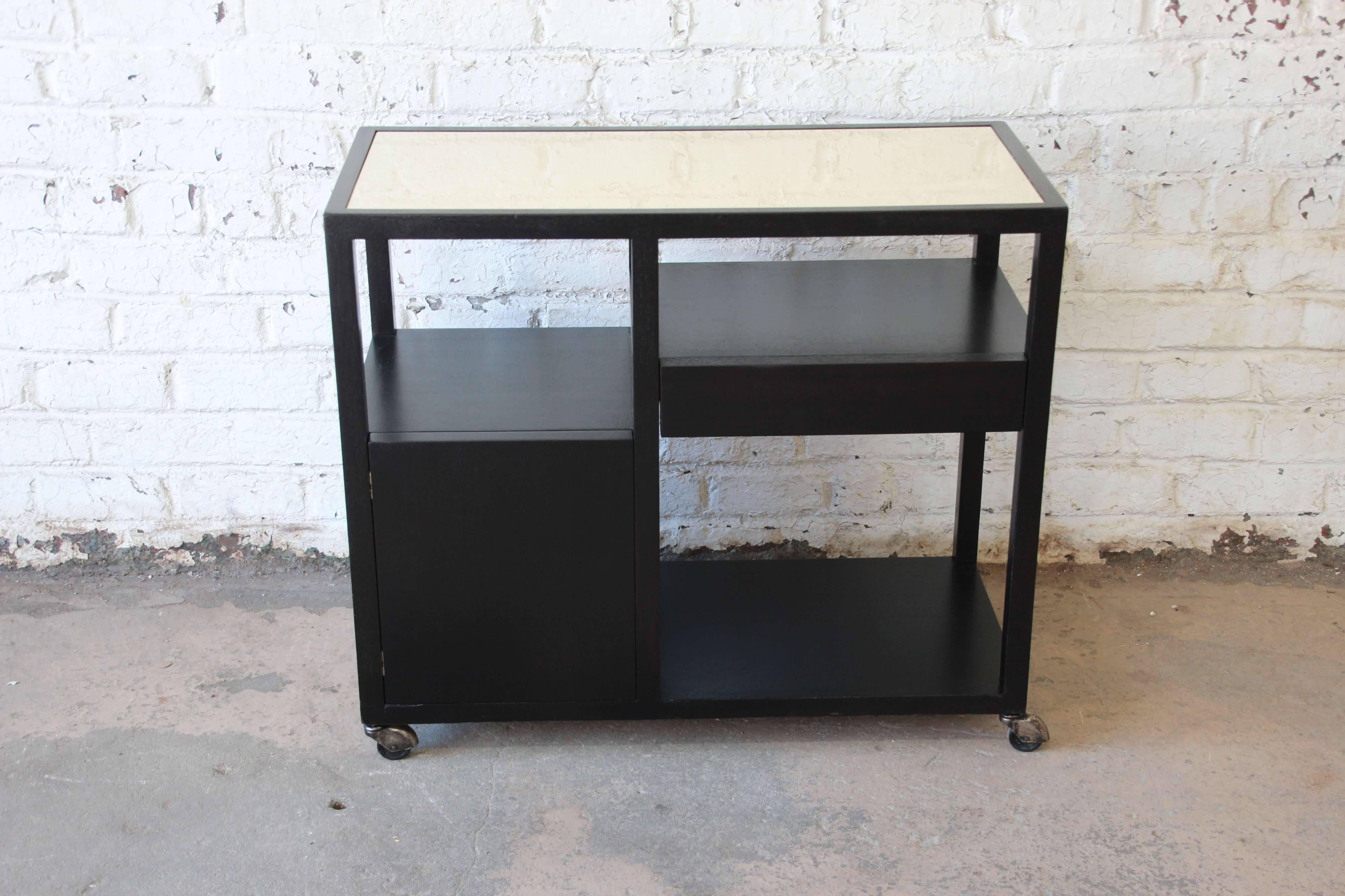 Offering a beautiful and recently refinished mahogany bar cart by Harvey Probber. The cart sits on original smooth rolling casters. The lower portion offers a shelf and cabinet space for storage. Just above is another shelf area and a drawer. The