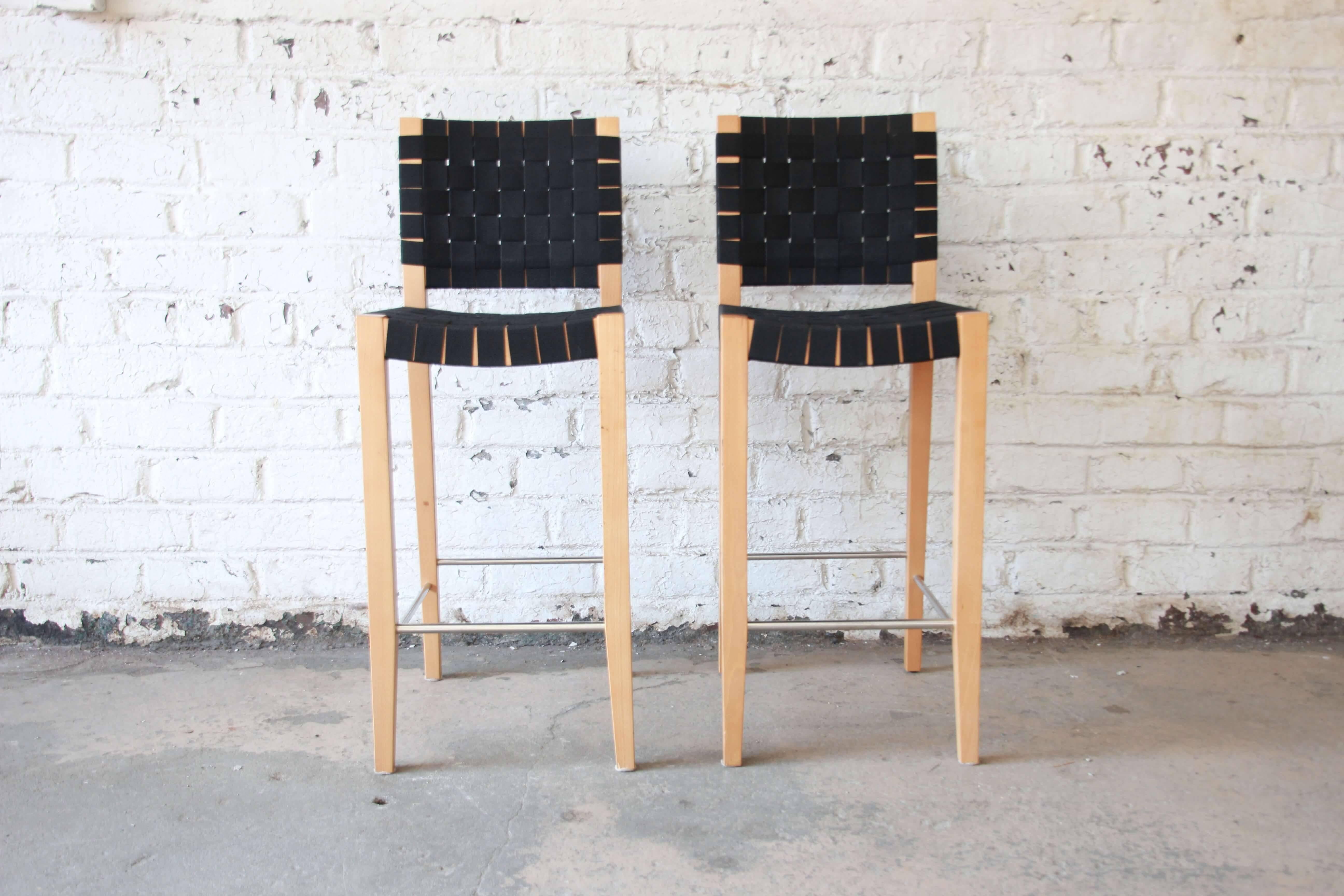 Offering a very nice pair of black canvas bar stools by Andreu World. These Jens Risome style stool have nice clean black canvas straps and sit on tall tapered legs. The base of the stools have metal footrest adding to the style and comfort. The