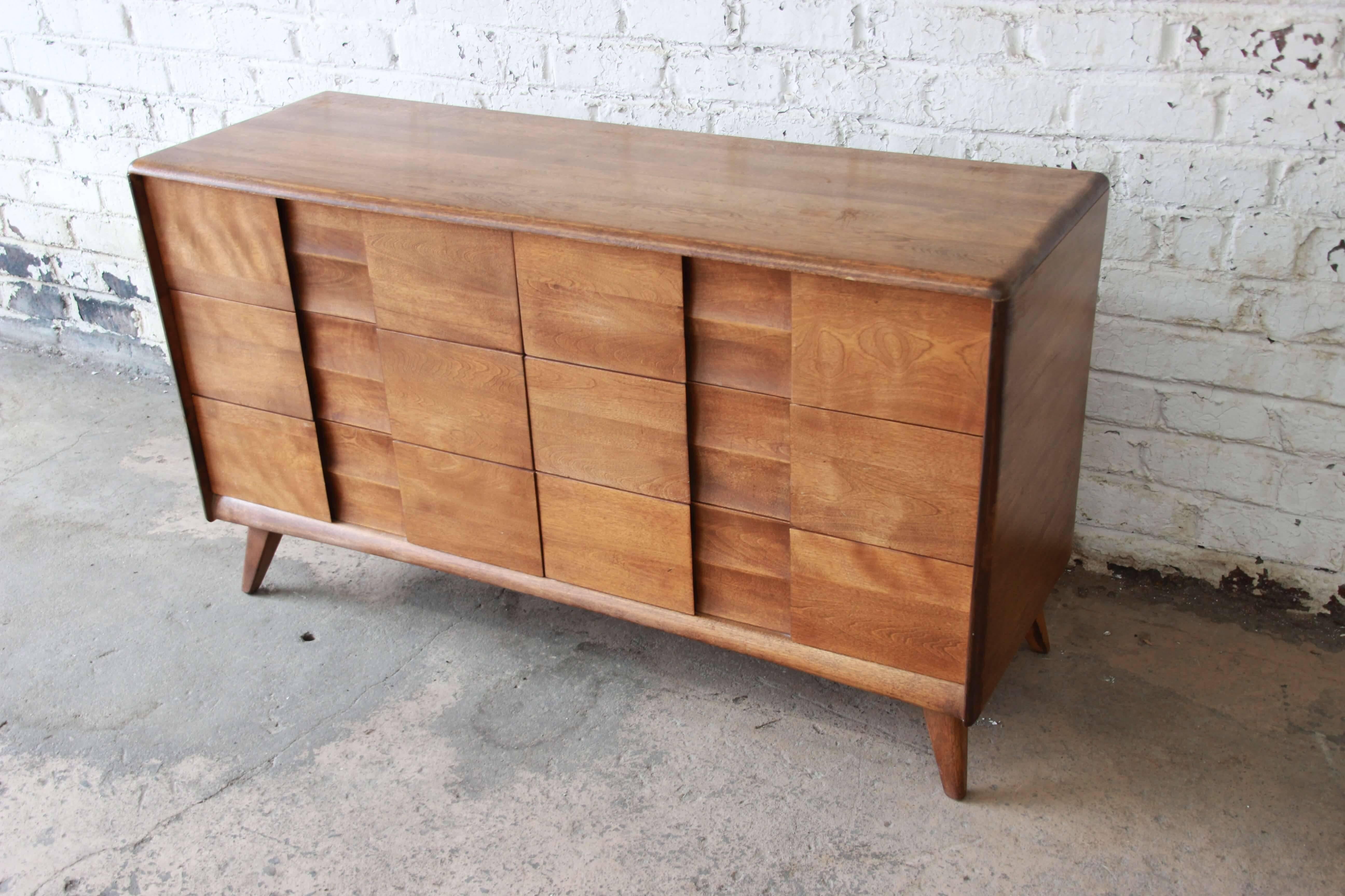 Offering a very nice six-drawer Heywood-Wakefield dresser in Wheat. The dresser has unique sculpted pulls and midcentury details. Each of the drawers open and close smoothly while providing ample roam for storage. It has nice tapered modern legs and