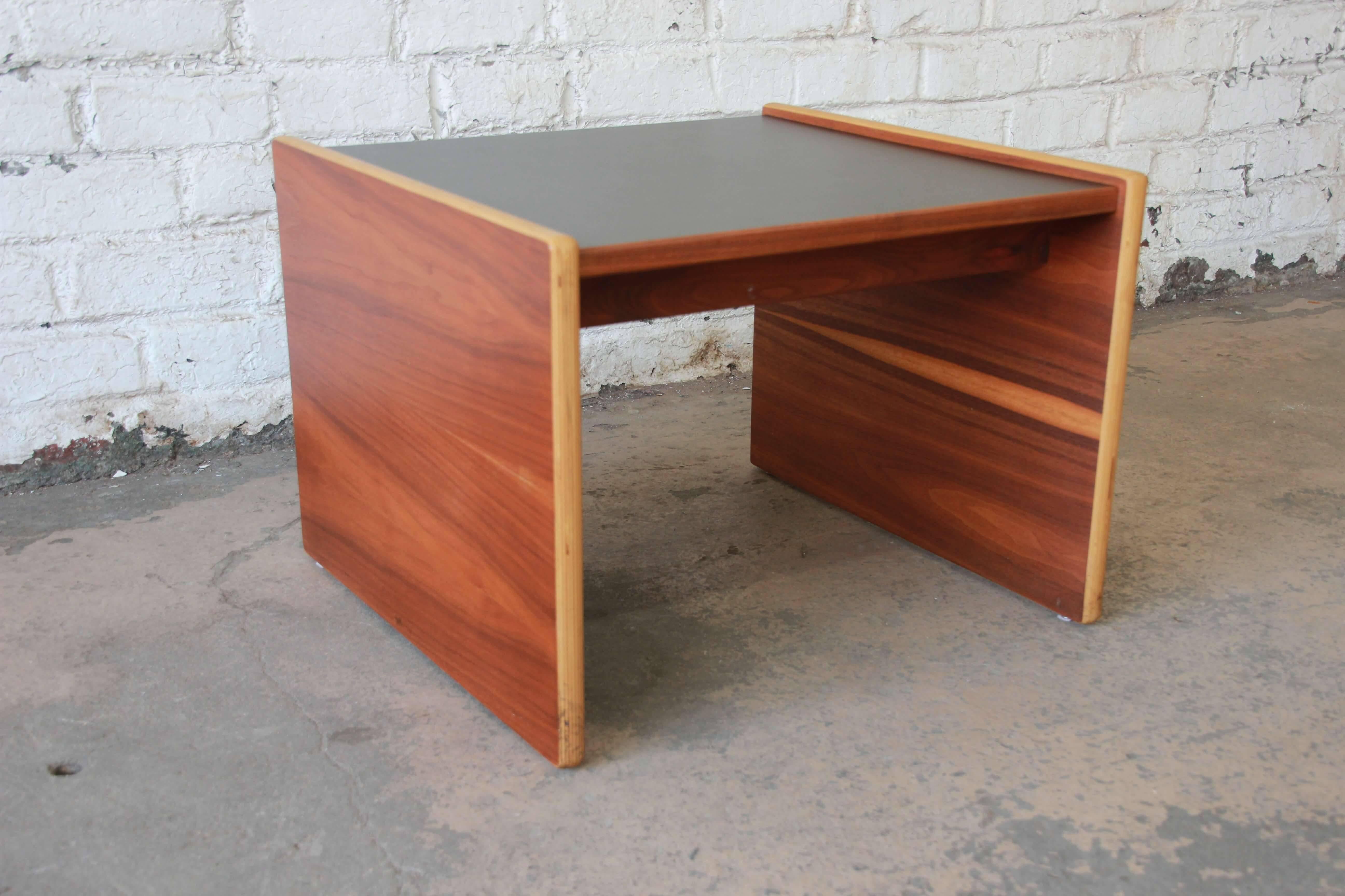 Offering a very nice and stylish Mid-Century Modern side table or bench by Jens Risom. The end table features a beautiful walnut wood grain on the legs that connect to a durable black laminate top. The table is in great vintage condition and is
