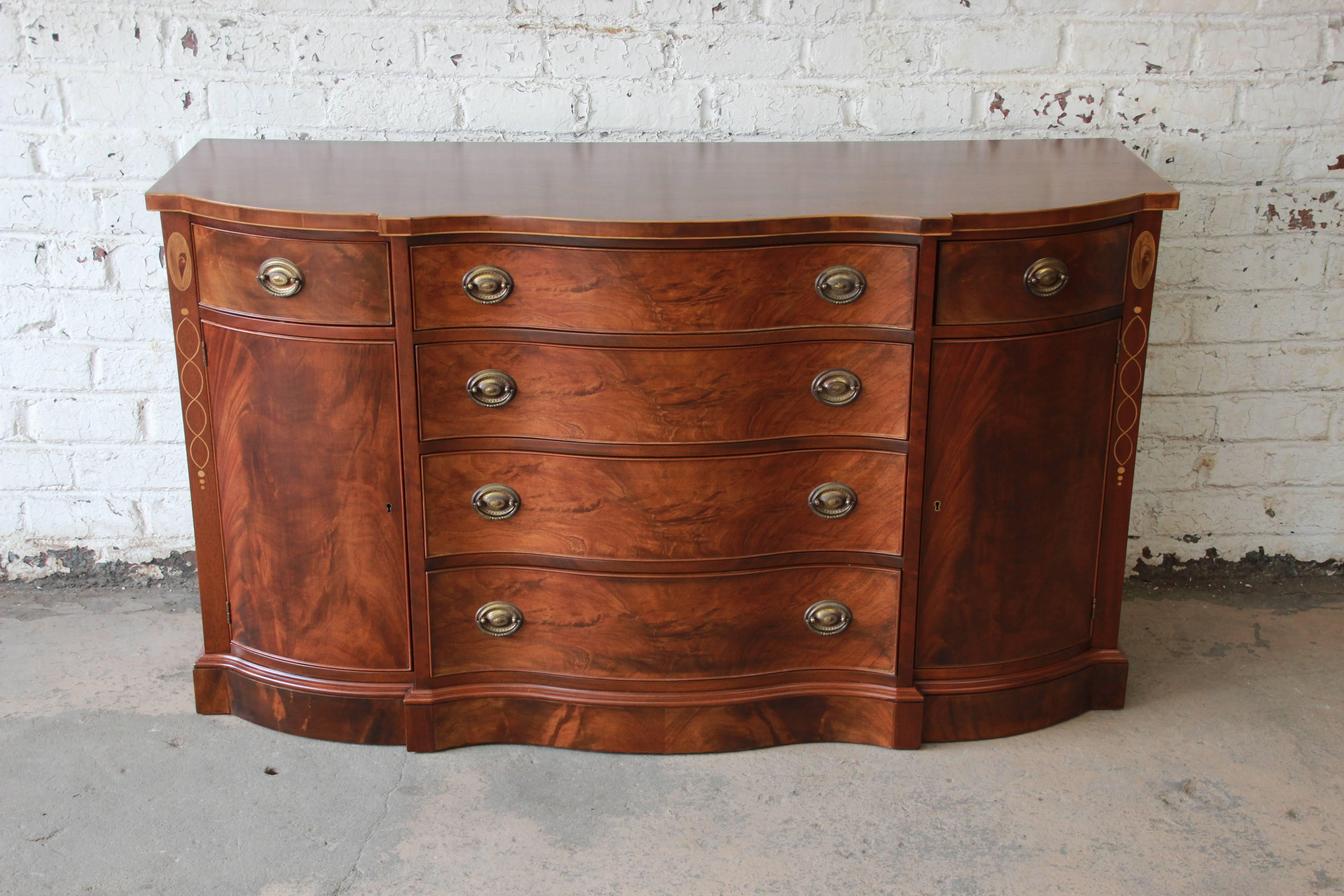 Offering a beautiful sideboard buffet by Drexel Furniture. This piece is part of the Wallace Nutting collection and has beautiful inlaid details with stunning wood grain that makes this a statement piece to any home. The piece feature s four large
