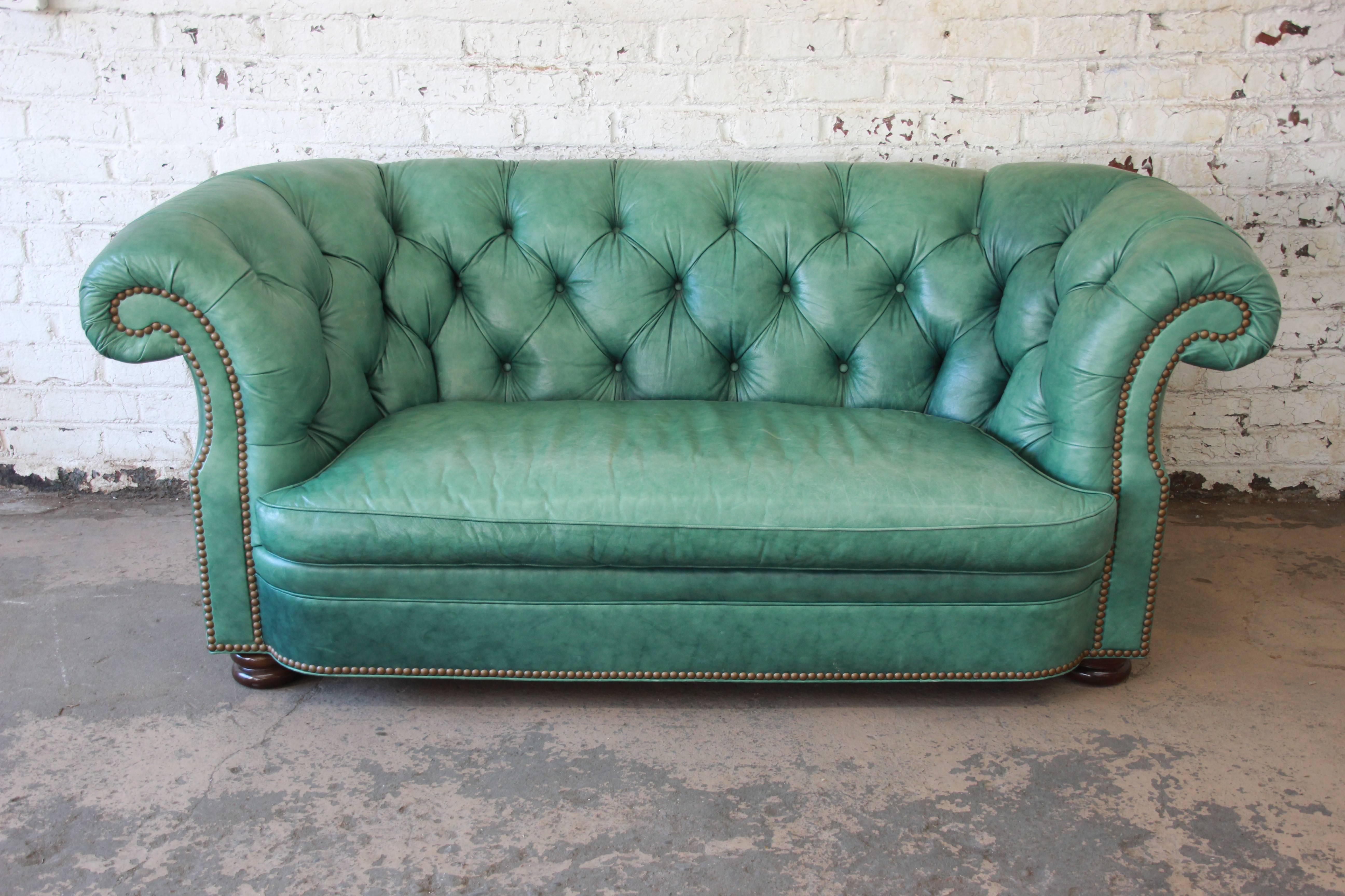 An outstanding vintage tufted leather Chesterfield style sofa by Hancock & Moore. The sofa features beautifully aged teal leather, with brass nailhead trim and solid mahogany bun feet. It is very comfortable and in very good vintage condition, with
