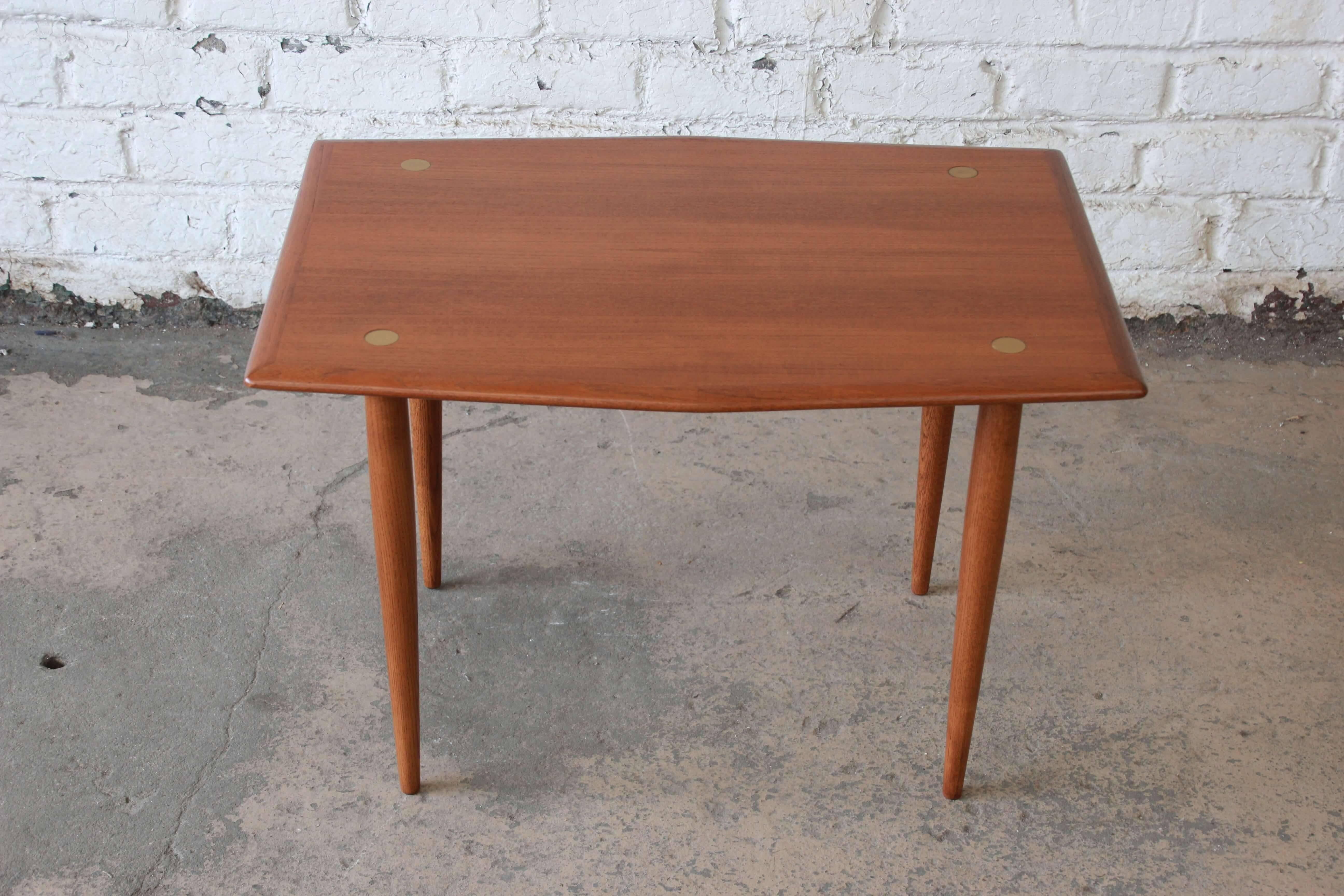 Offering stunning newly refinished Swedish Modern side table by DUX. This teak table has very nice brass accents that pop out of the beautiful teak wood grain. The table is in excellent condition with a unique hexagonal shape.