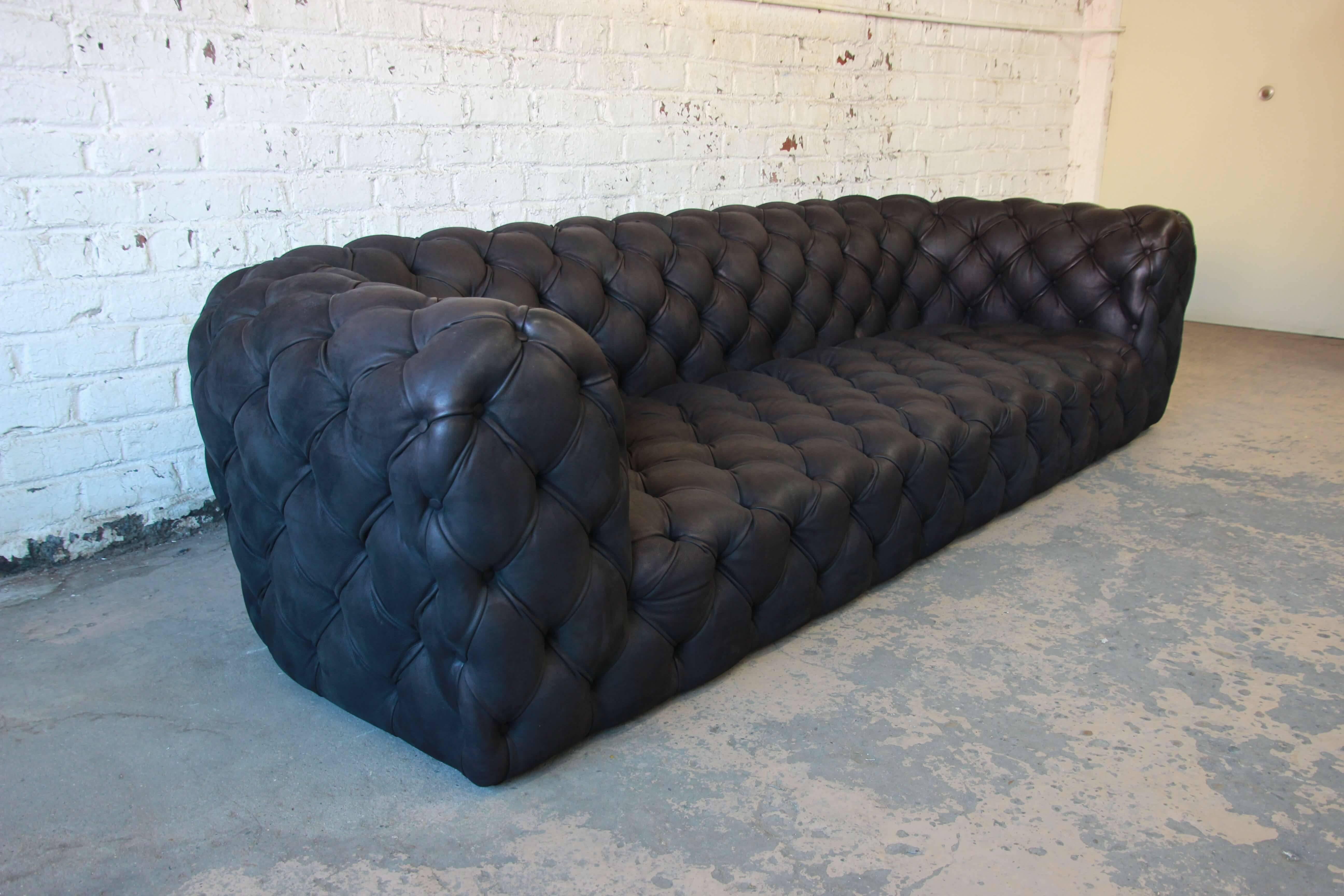 Offering an outstanding Italian tufted black leather Chester Moon sofa designed by Paola Navone for Baxter. The sofa features high grade black leather upholstery, tufted on all sides. The leather is soft and comfortable. A modern take on the English