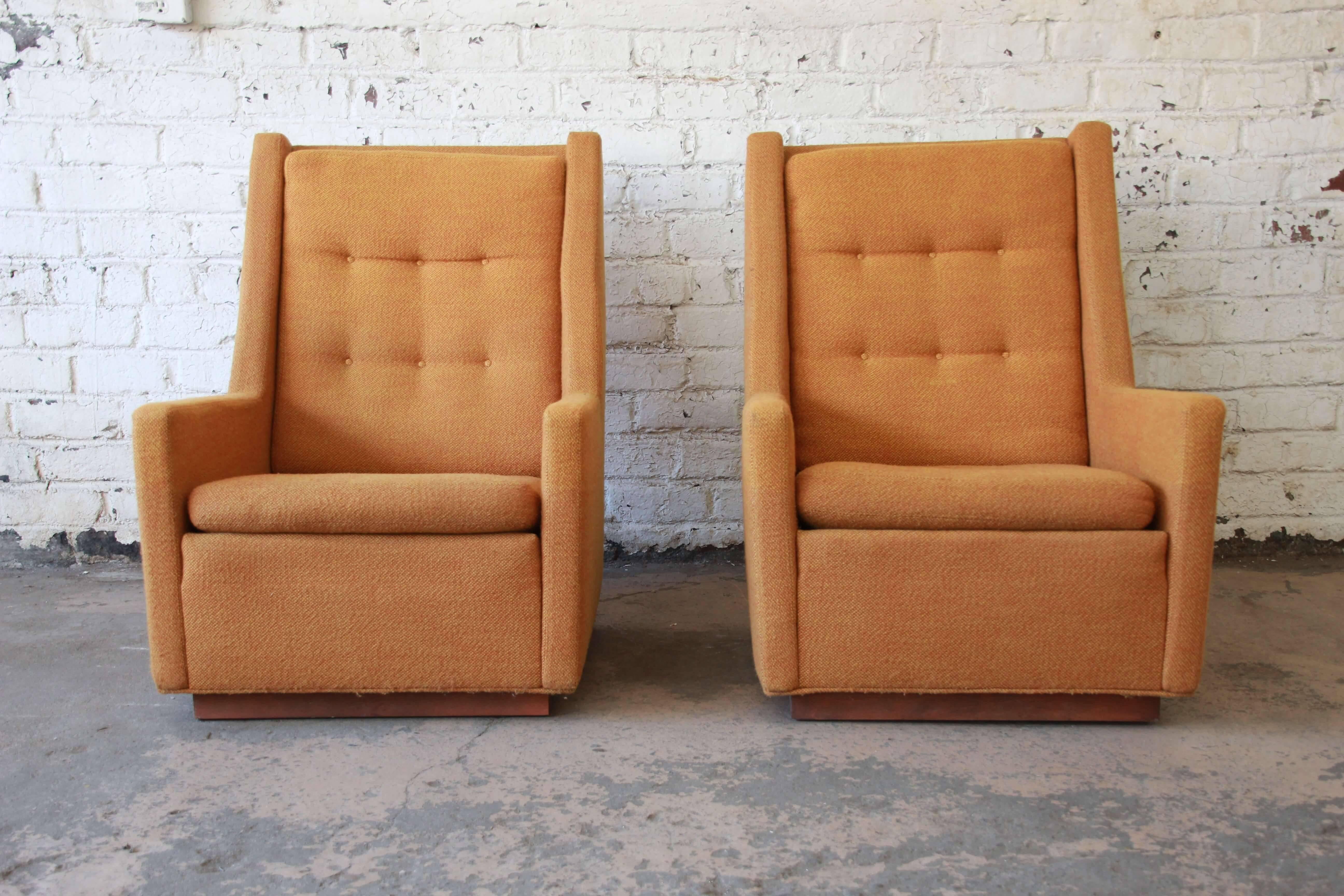 Offering an original pair of Mid-Century Modern lounge chairs and ottoman by Milo Baughman for James, Inc. The chairs are apart of the 'Articulate Seating' line and have original orange a yellow upholstery and feature a walnut plinth base. The