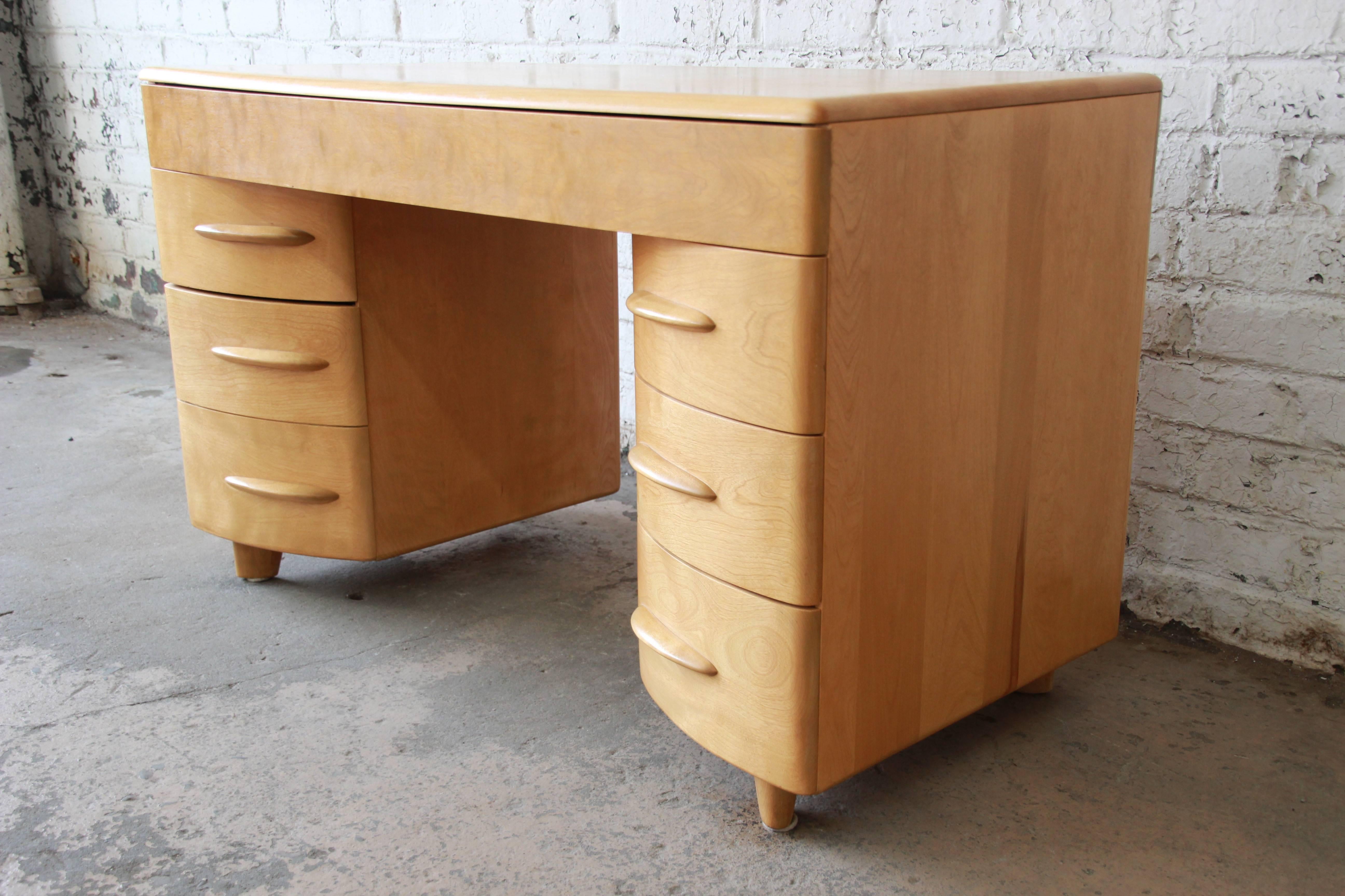 An exceptional 1950s Mid-Century Modern desk by Heywood Wakefield. The desk features solid maple construction, with beautiful wood grain and sculpted drawer pulls. It offers ample room for storage, with six drawers. The top middle drawer is divided